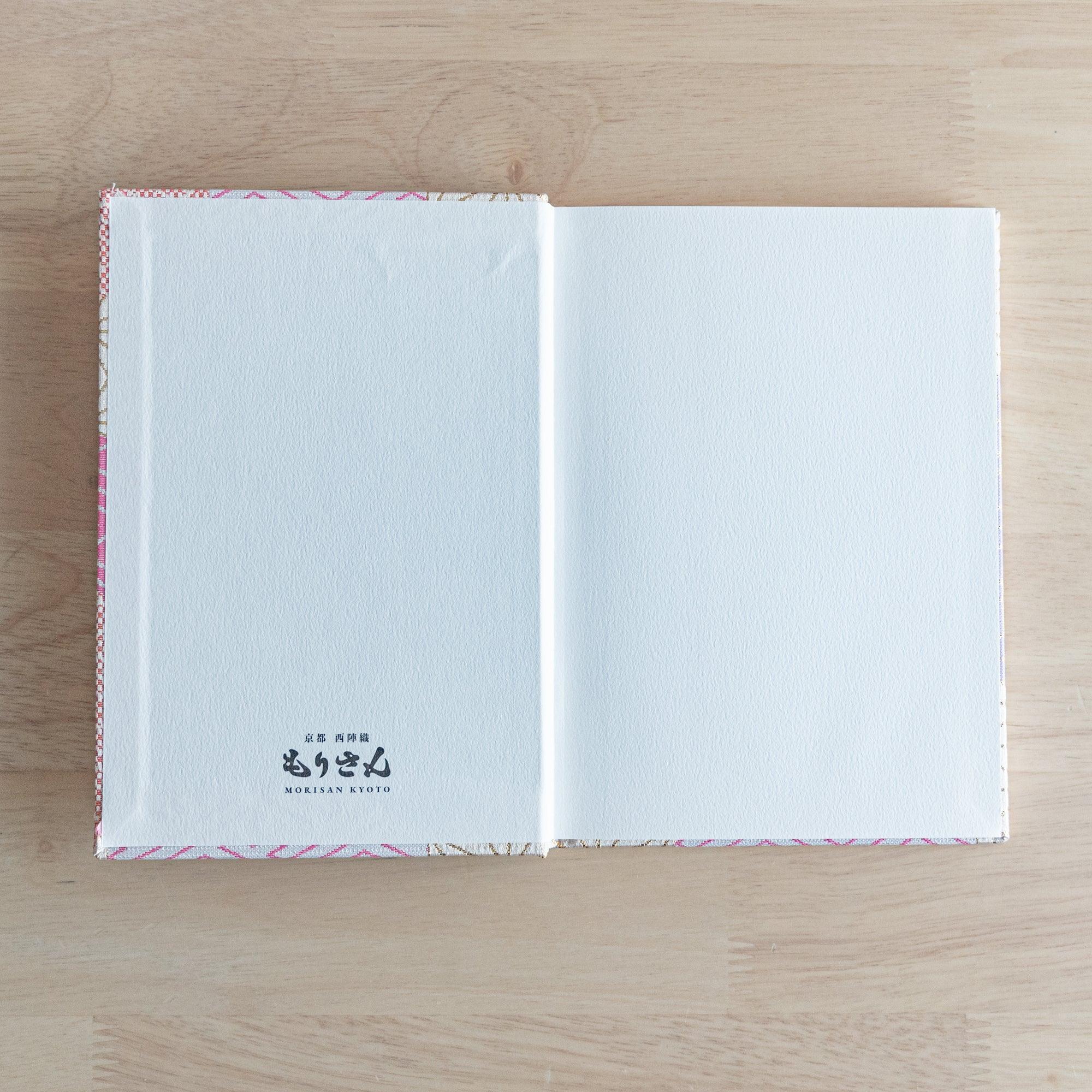 The inner cover of a Japanese notebook with plain white pages and the "Morisan Kyoto" logo printed on the bottom left.