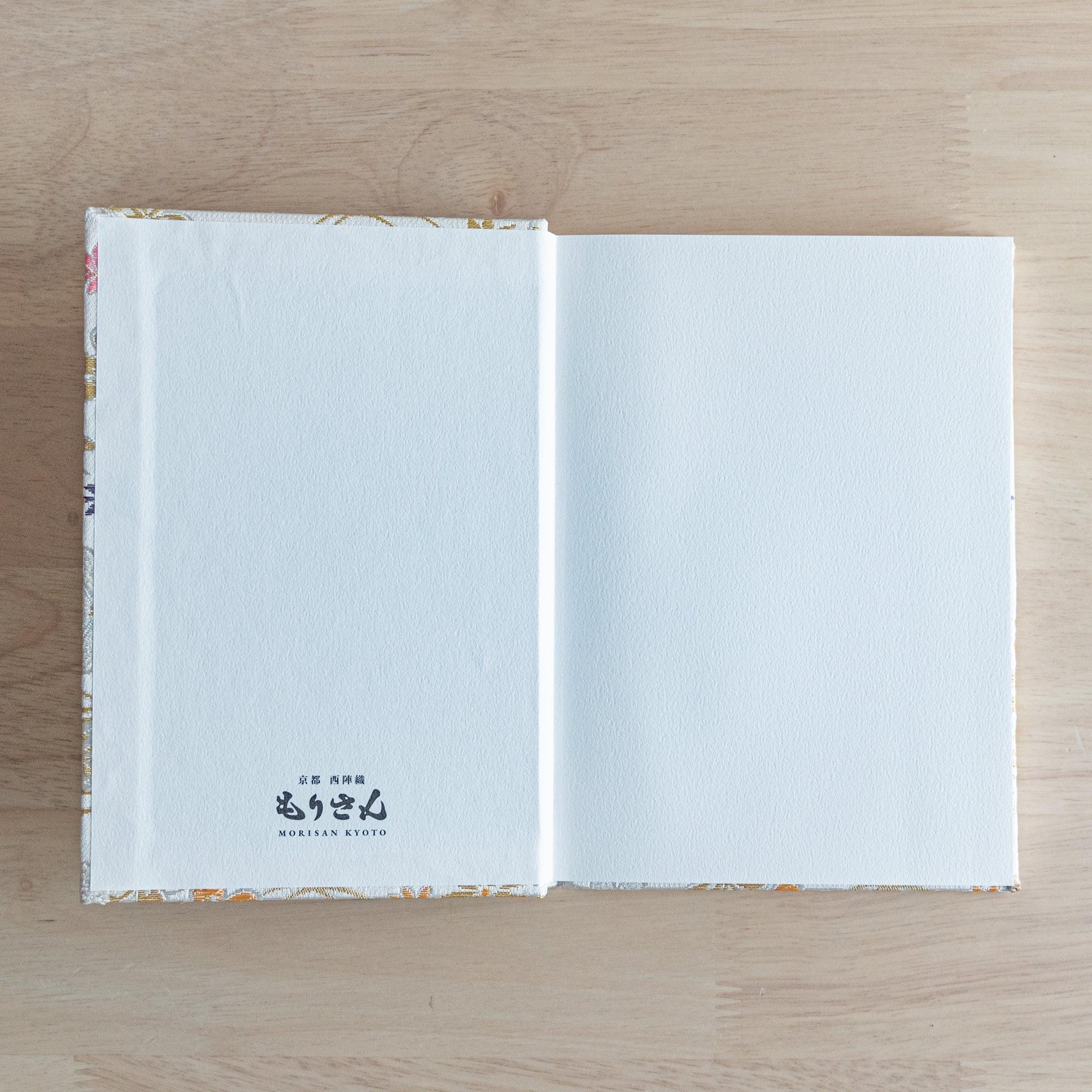The inner cover of a Japanese notebook with plain white pages and the "Morisan Kyoto" logo printed on the bottom left.