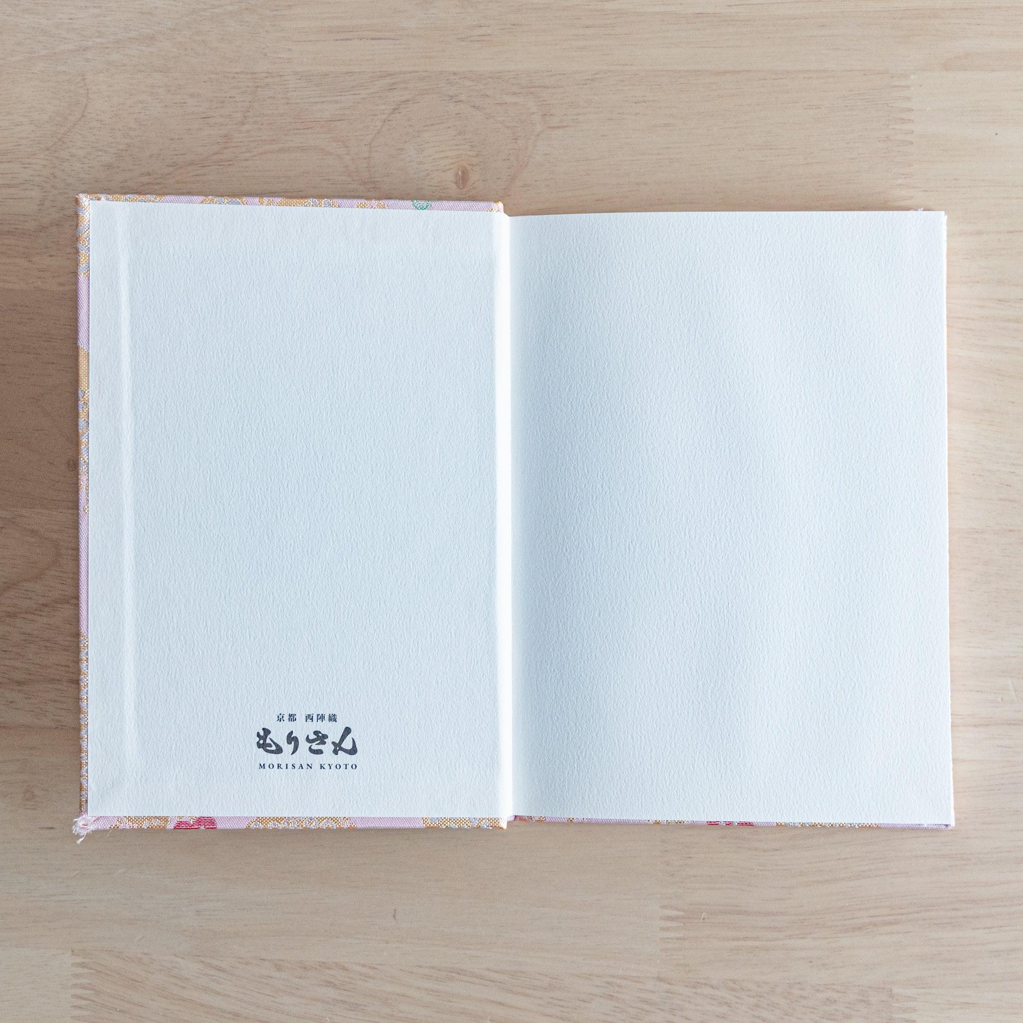 The inner cover of a Japanese notebook with plain white pages and the "Morisan Kyoto" logo printed on the bottom left.