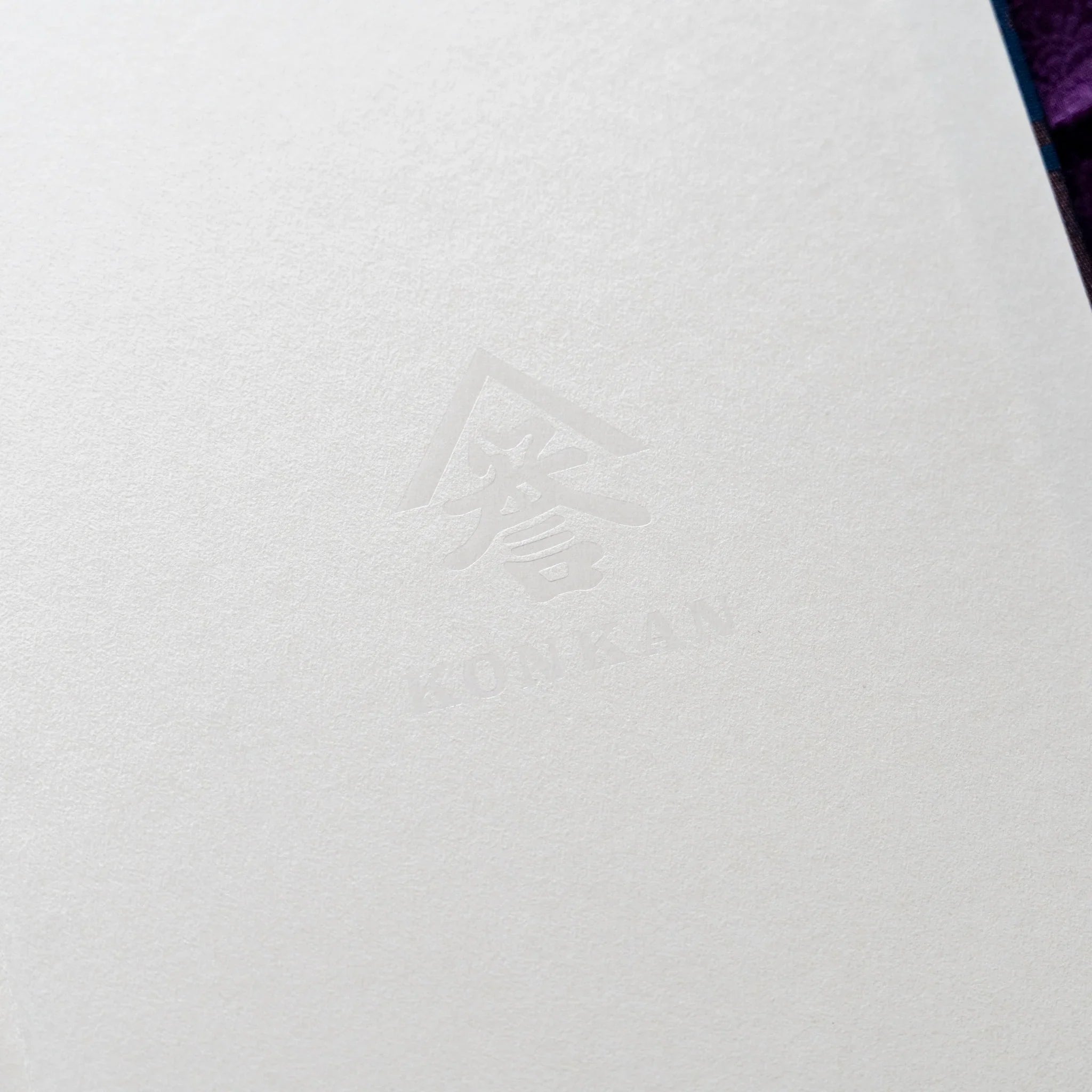 Oni Kiri Nishijin silk Homeicho notebook inner cover showing cream endpaper with KONKAN logo embossed in center