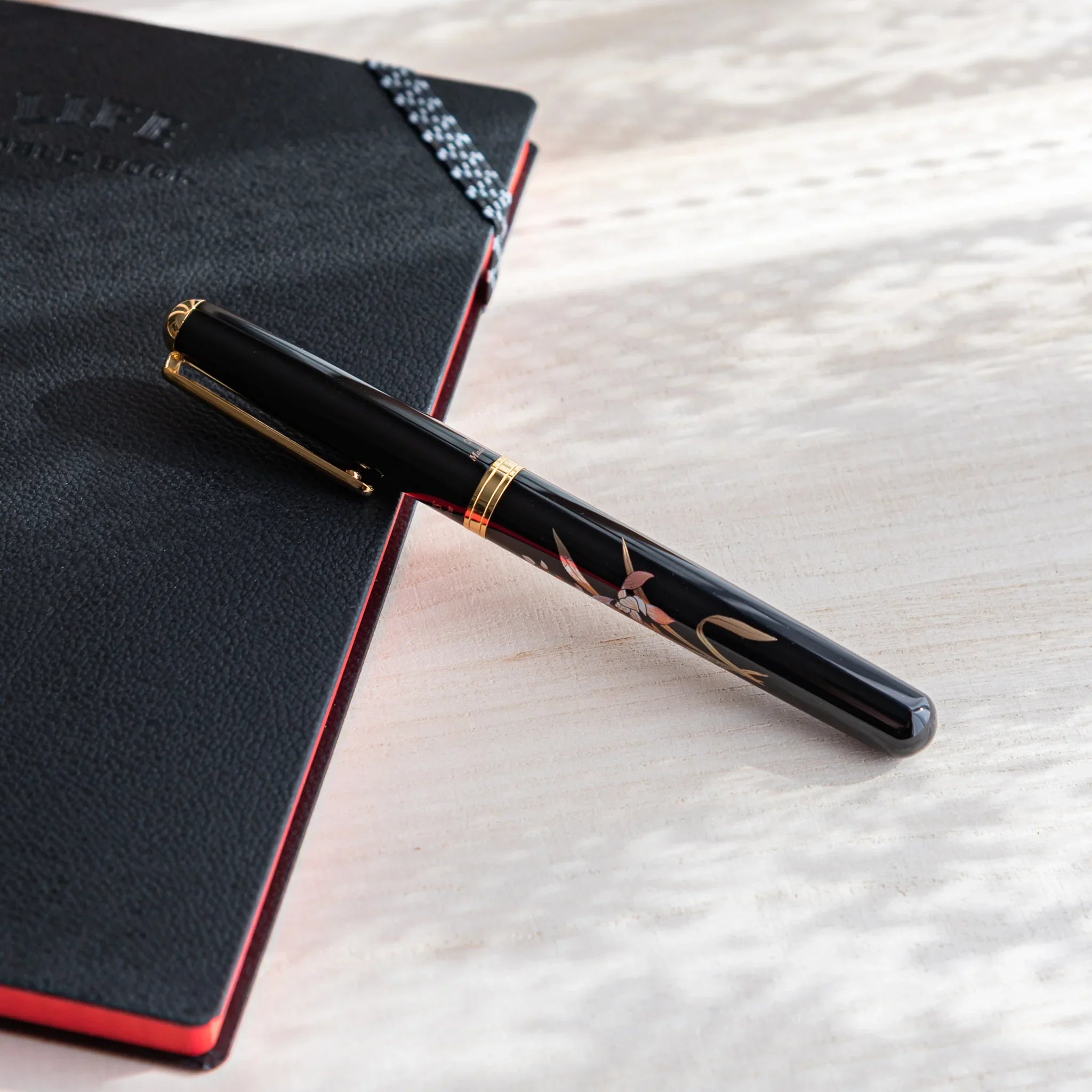 Orchid flower Yamanaka fountain pen with lacquer design shown in composition displayed in composition