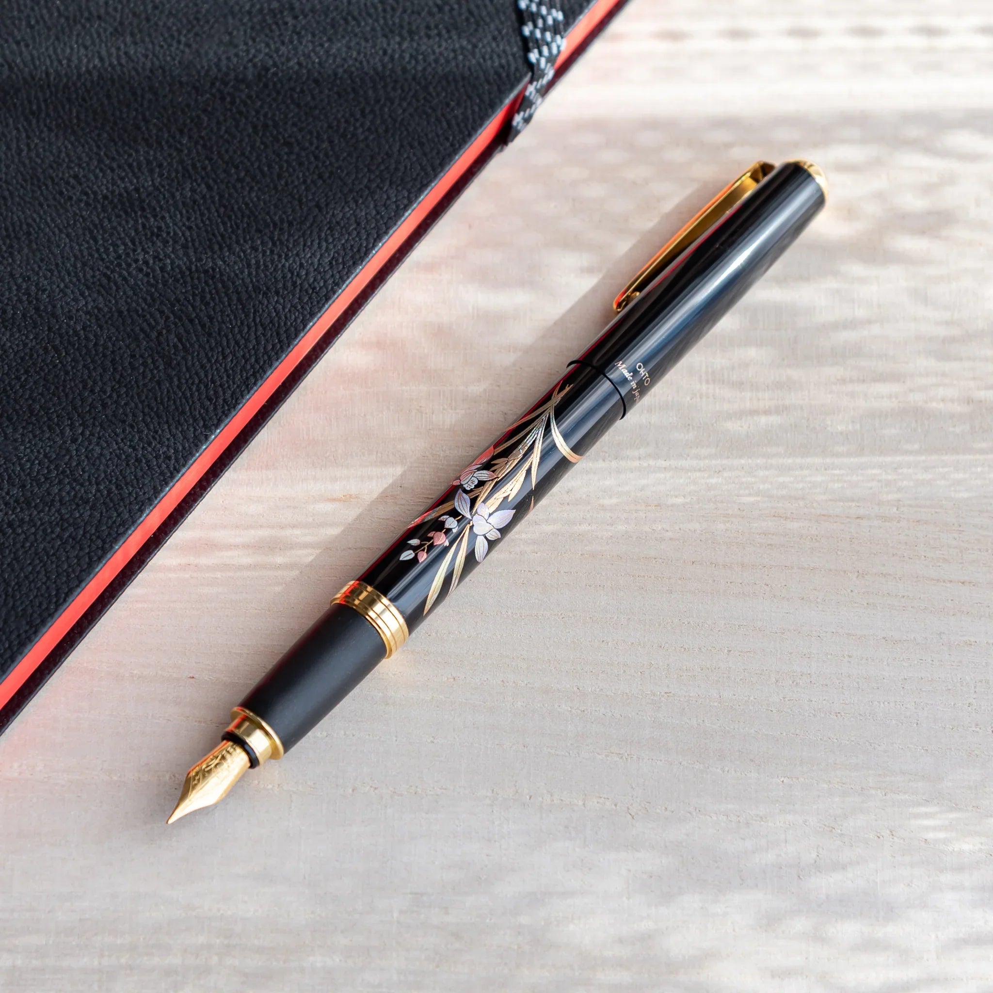 Orchid flower Yamanaka fountain pen with lacquer design shown in composition in detail view composition