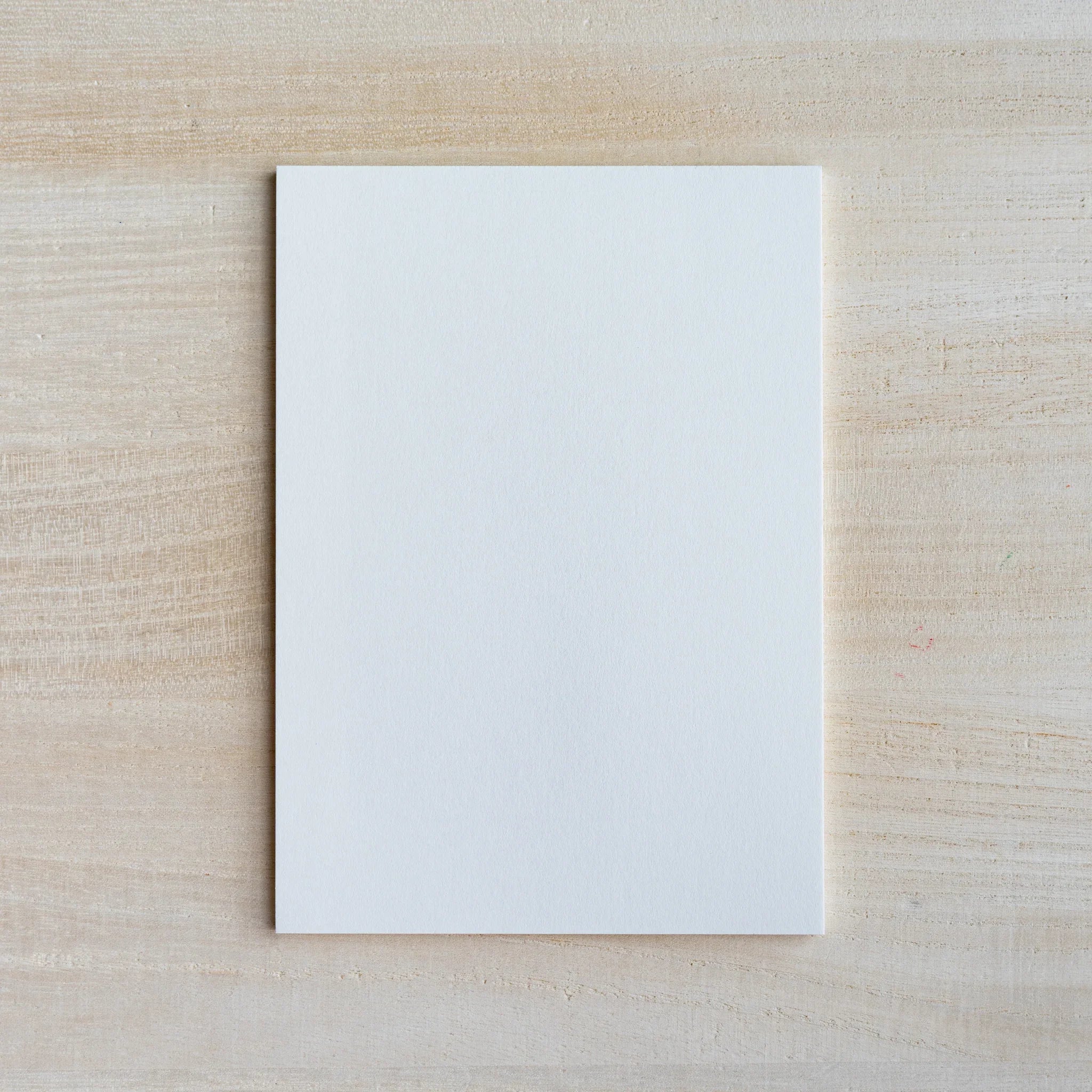 Single blank white writing sheet from the Egg Shell pad on light wood