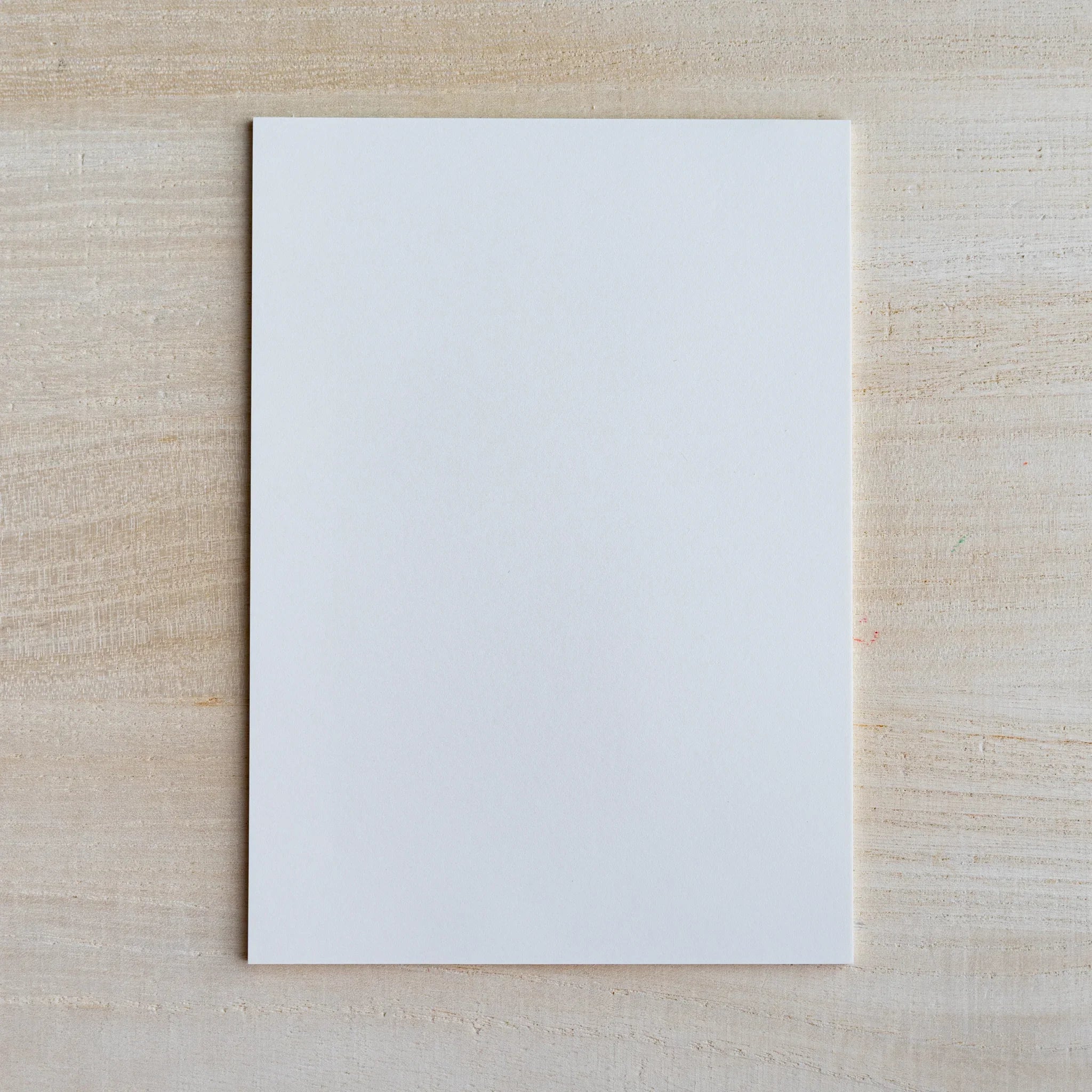 Single blank white sheet of Japanese paper from the Paper tasting pad on light wood