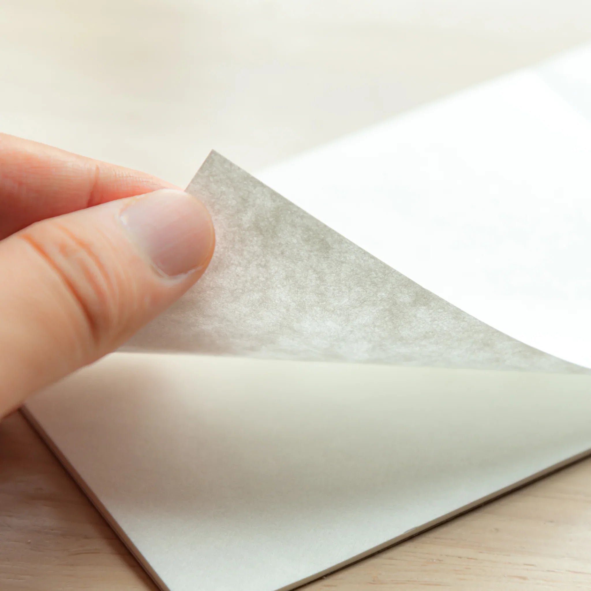 Hand turning the page with visible fibers from Paper Tasting Writing Pad Set.