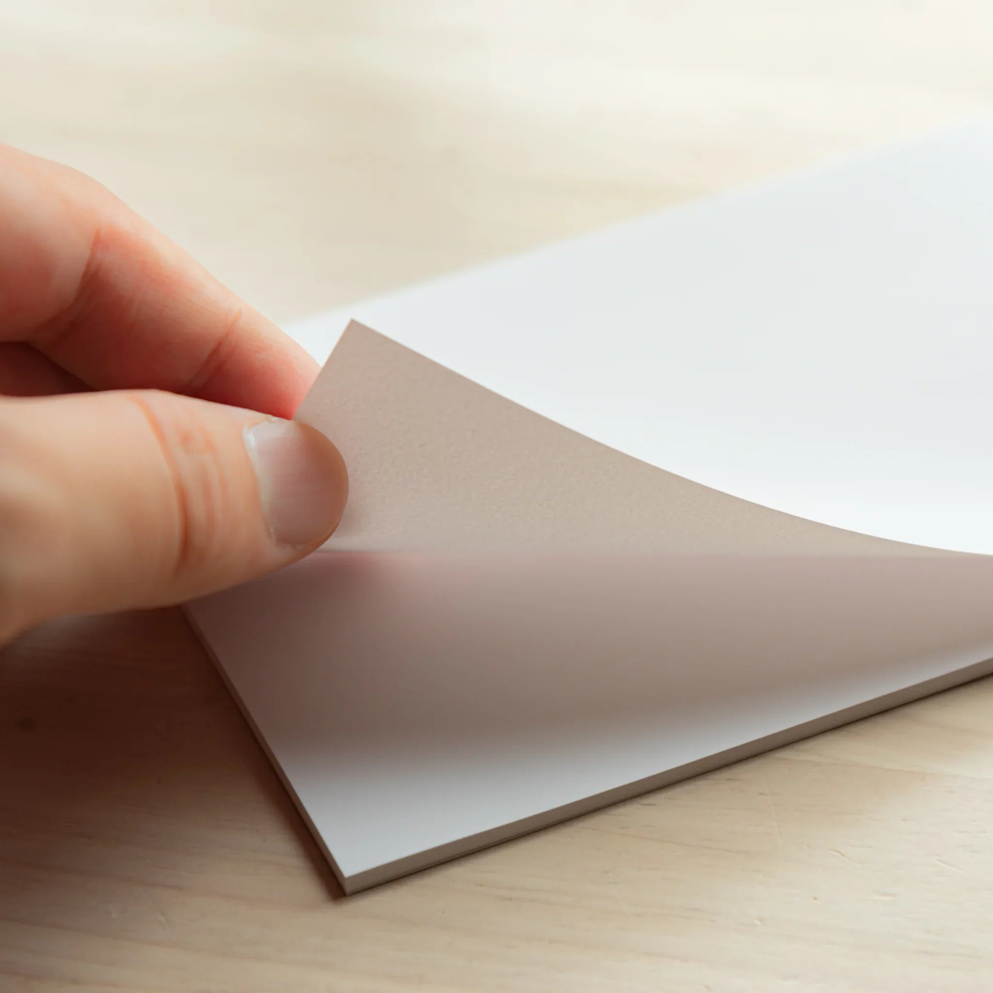 Page being lifted from Paper Tasting Writing Pad Set Silky vol.3, Japanese Note Book sampler showcasing thin flexible sheets.