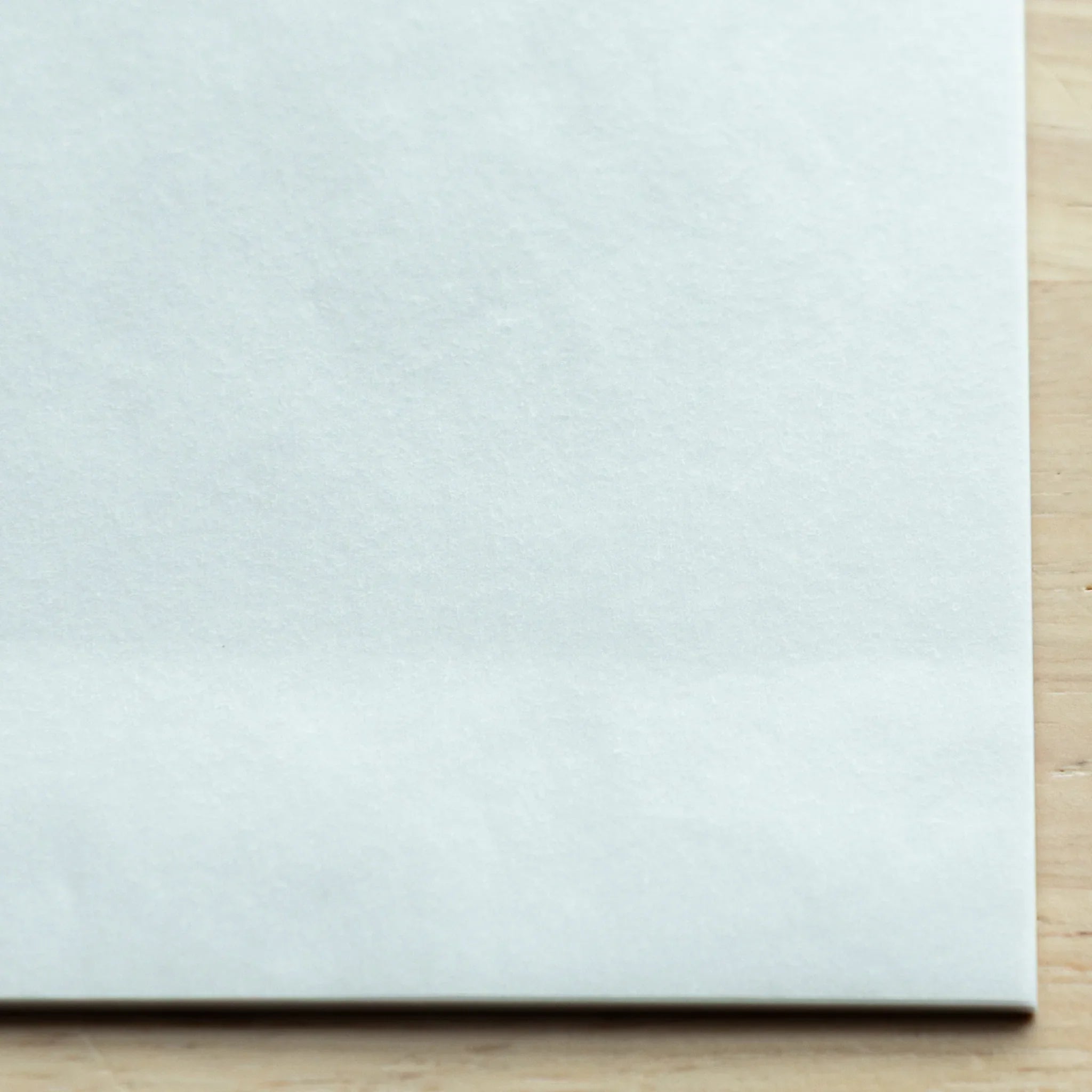 Multiple translucent paper samples fanned displaying subtle variations in opacity levels across complete paper collection