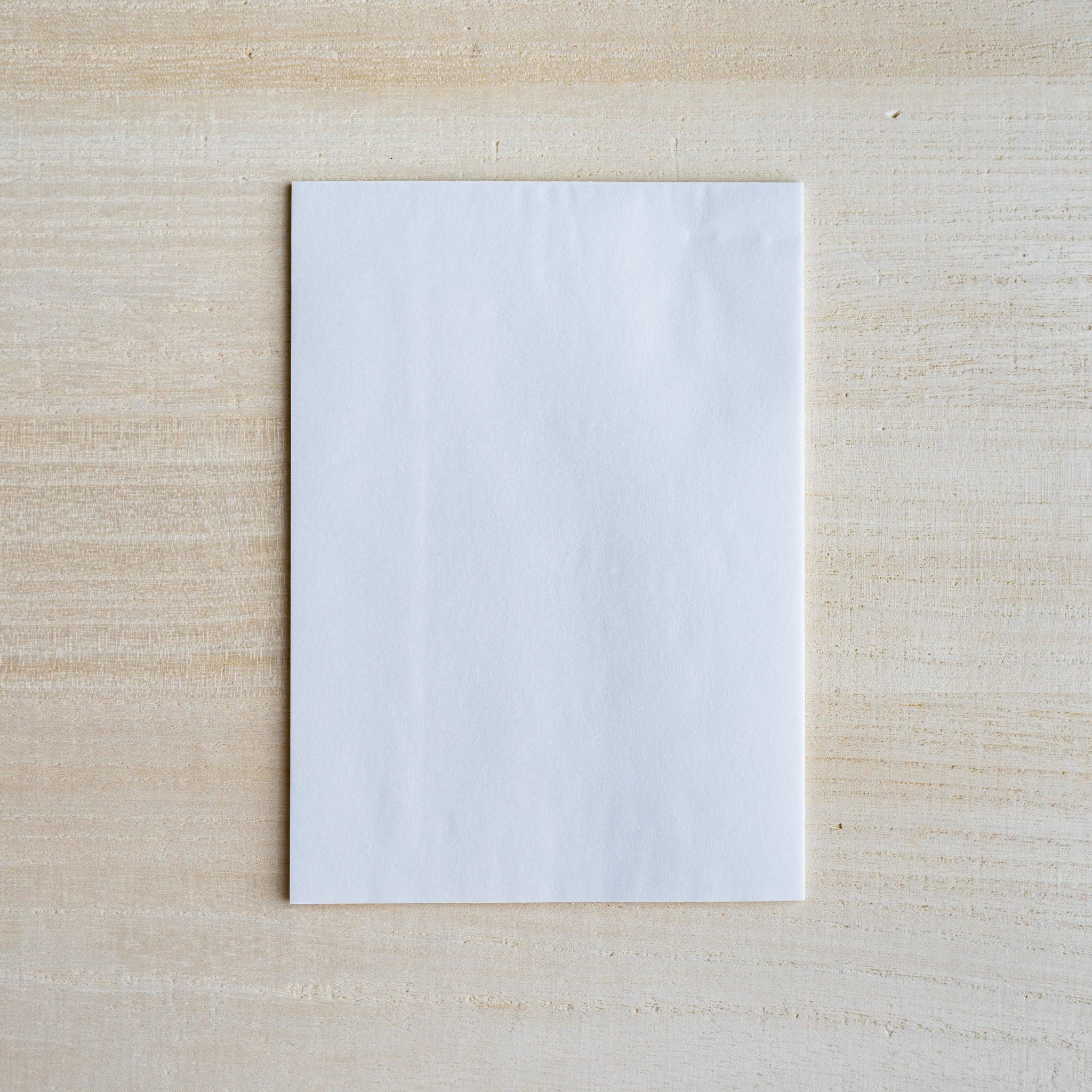 Single semi-transparent translucent writing sheet on light wood surface