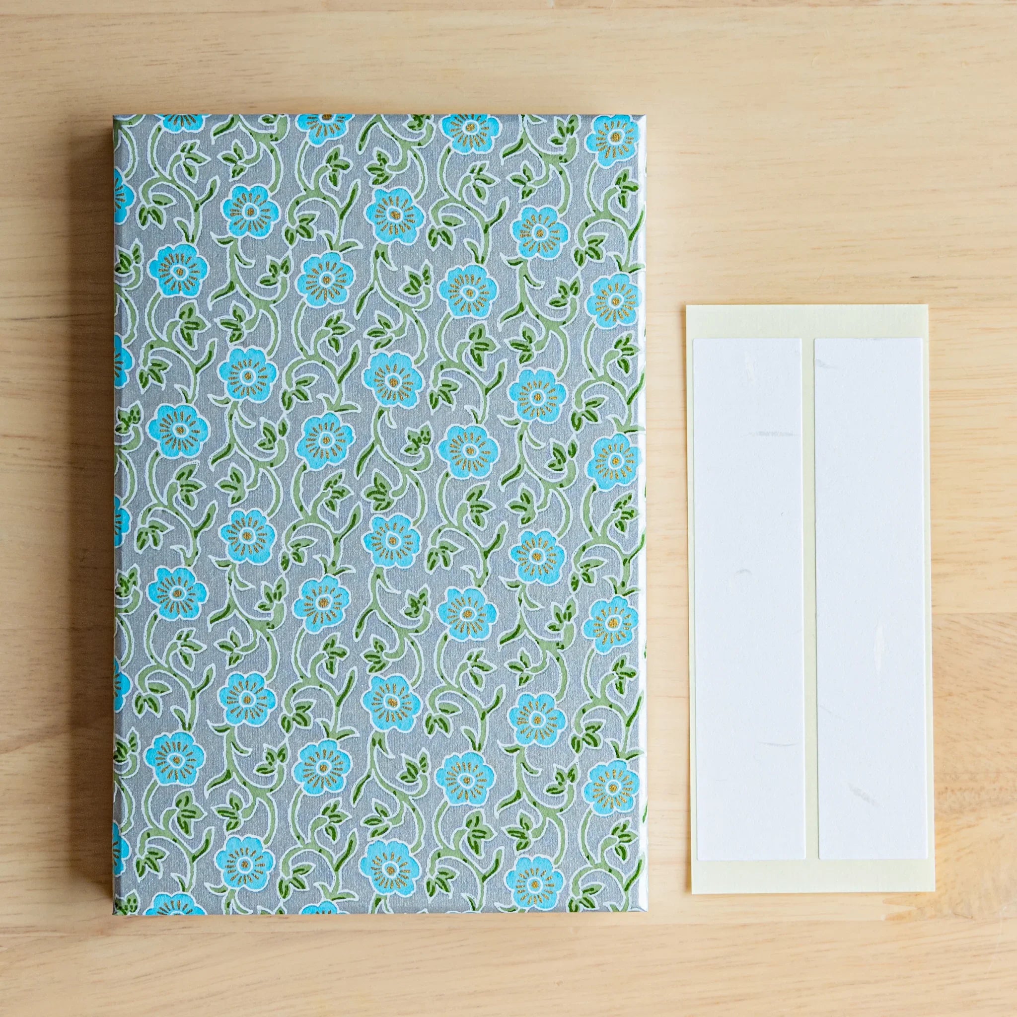 Pastel Blue Flower Washi Goshuincho Stamp Book angled view with turquoise flowers on pale gray washi