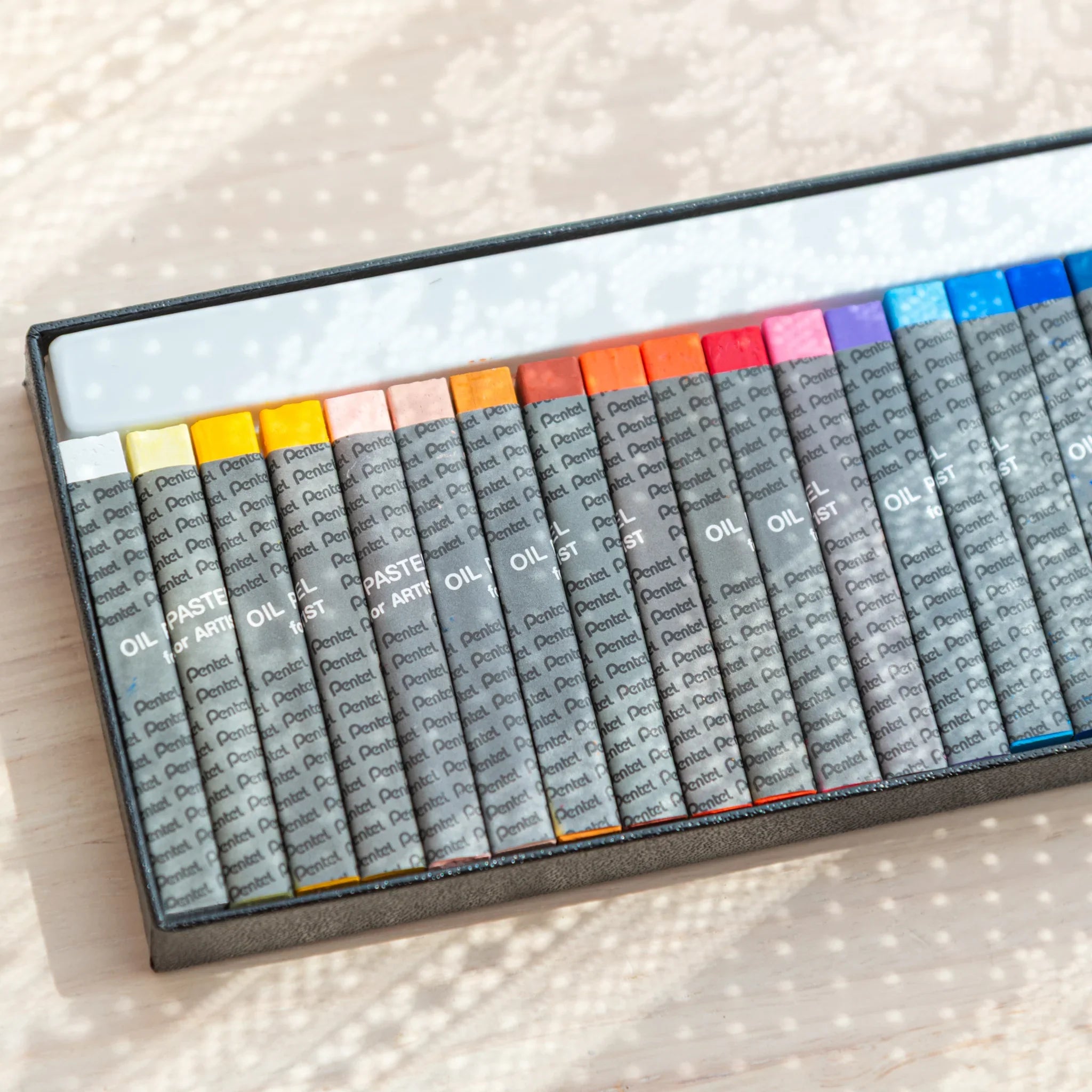 Close-up of warm-toned Pentel Japanese Oil Pastels in a box, perfect for arts and crafts use.