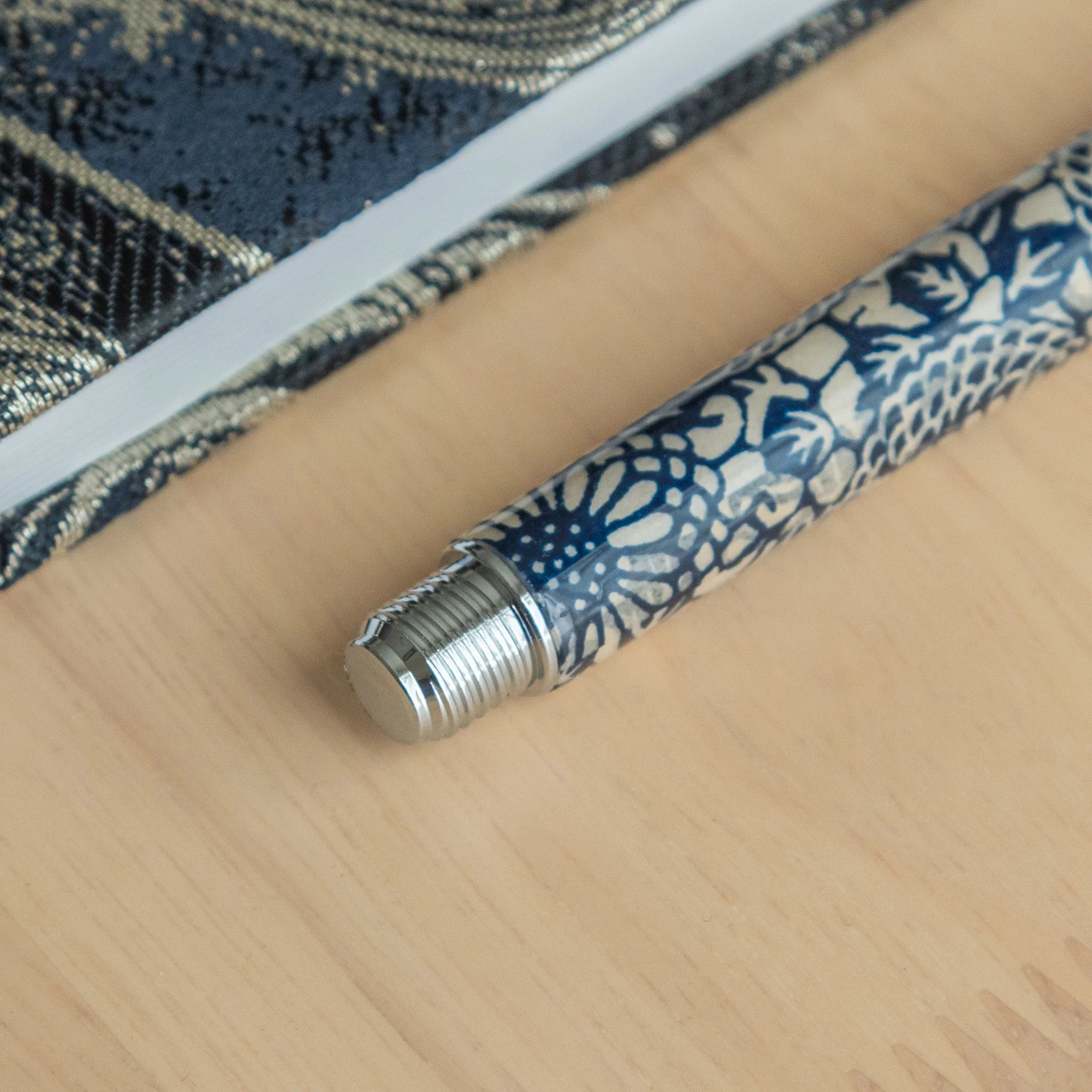 Peony fountain pen barrel section closeup showing white peony flowers and foliage details on dark navy Mino washi material
