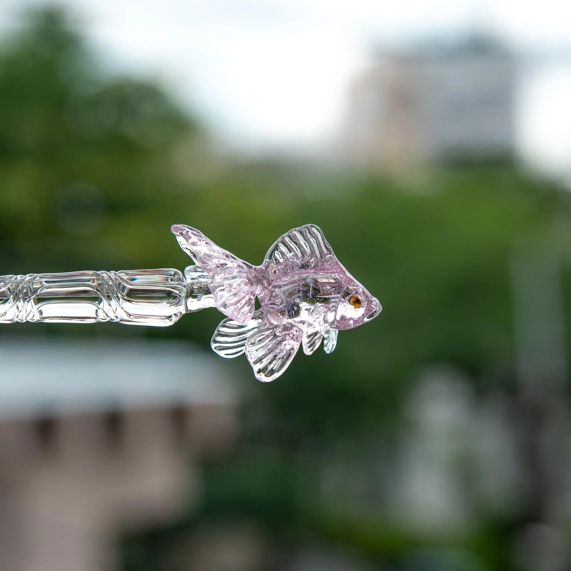 Pink goldfish glass dip pen being held for writing demonstrating hand positioning and metal nib application shine
