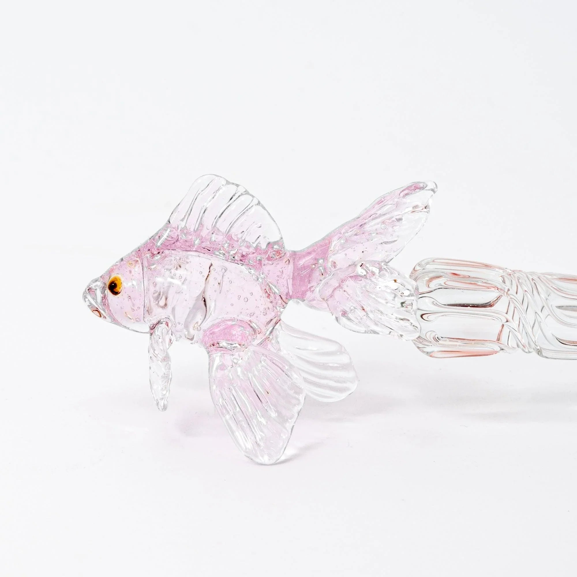 Pink glass dip pen with fish motif shown at angle displaying translucent material and twisted metal nib with holder