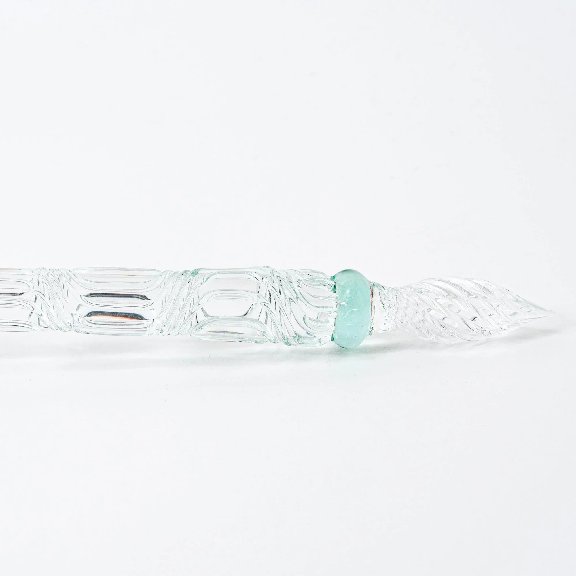 Japanese goldfish glass dip pen with pink coloring displayed with metal nib against neutral background with holder