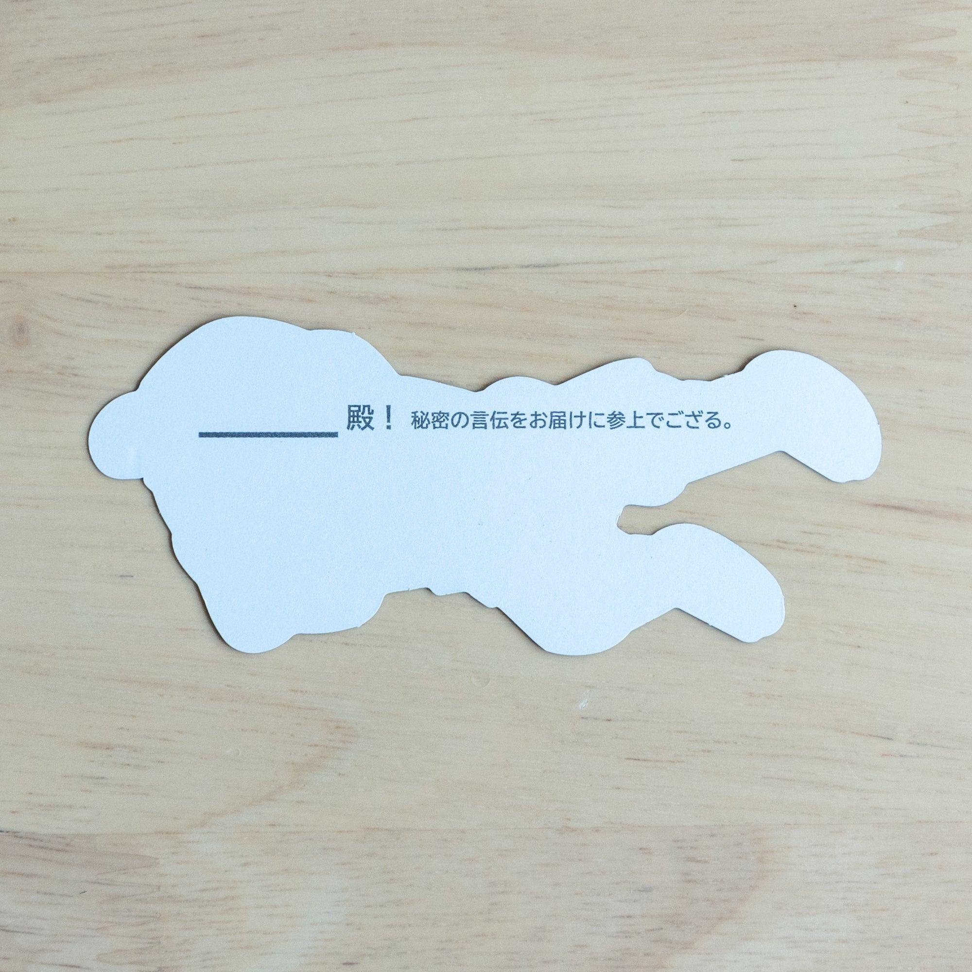 White writing side of ninja die-cut card on wood, blank with preprinted Japanese text and a line for recipient name