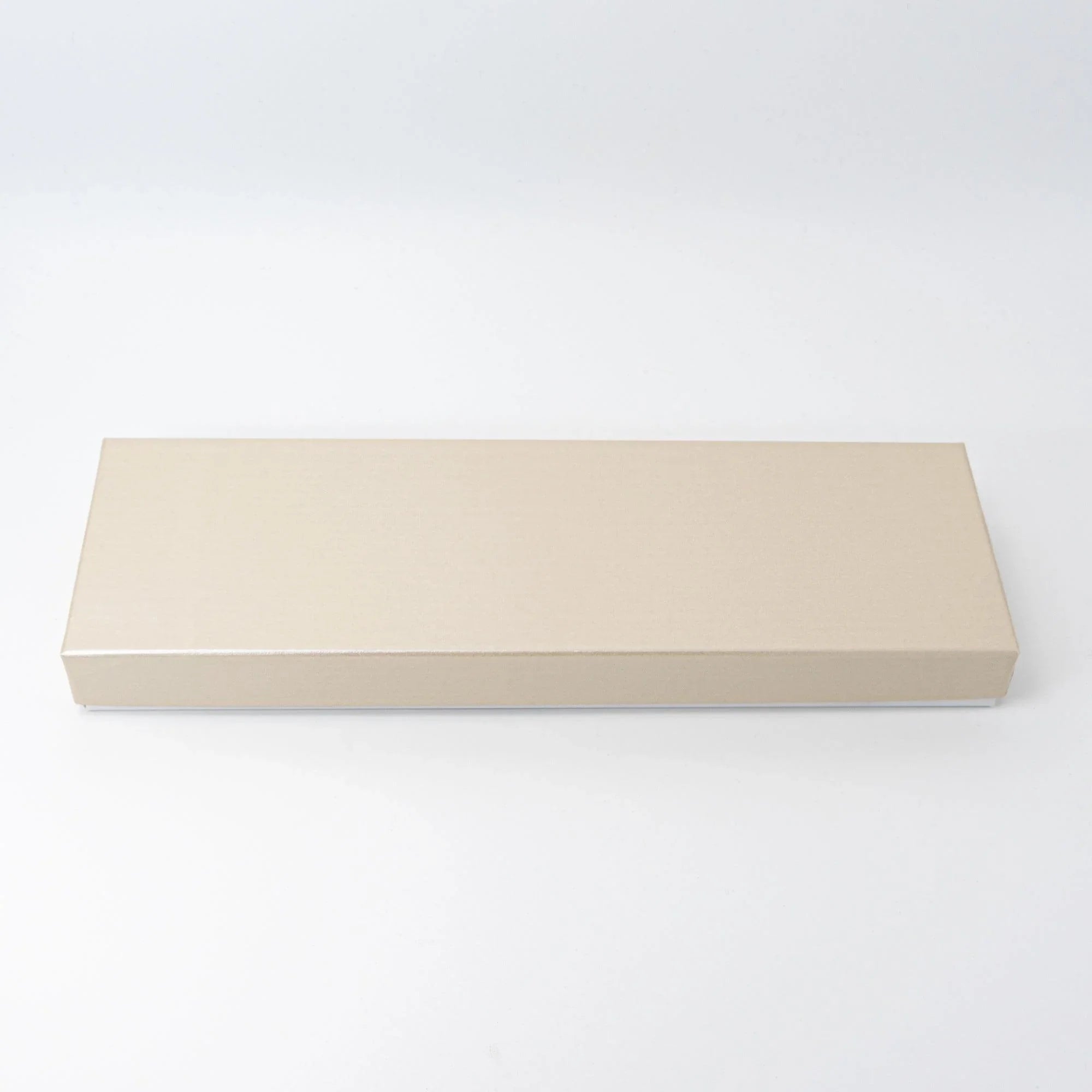 Closed slim cream gift box for shippo ware pen tray on white background, showing elongated rectangular shape with plain lid