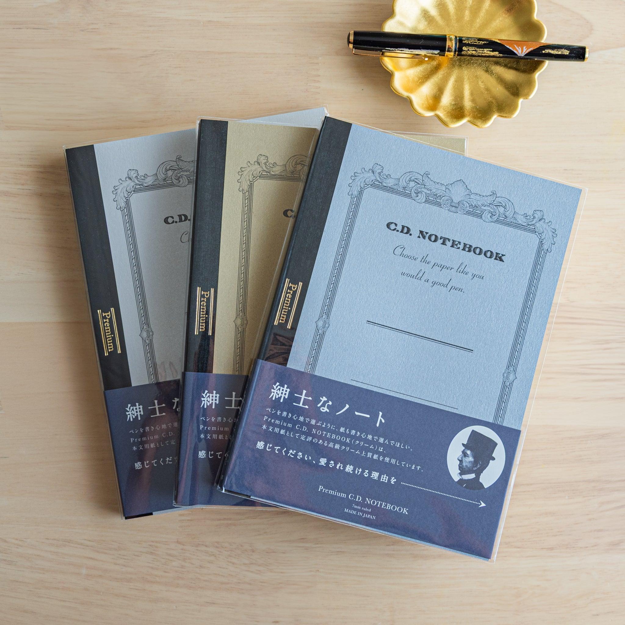 Three Japanese notebooks from the Premium CD series with a fountain pen, representing refined Japanese stationery style