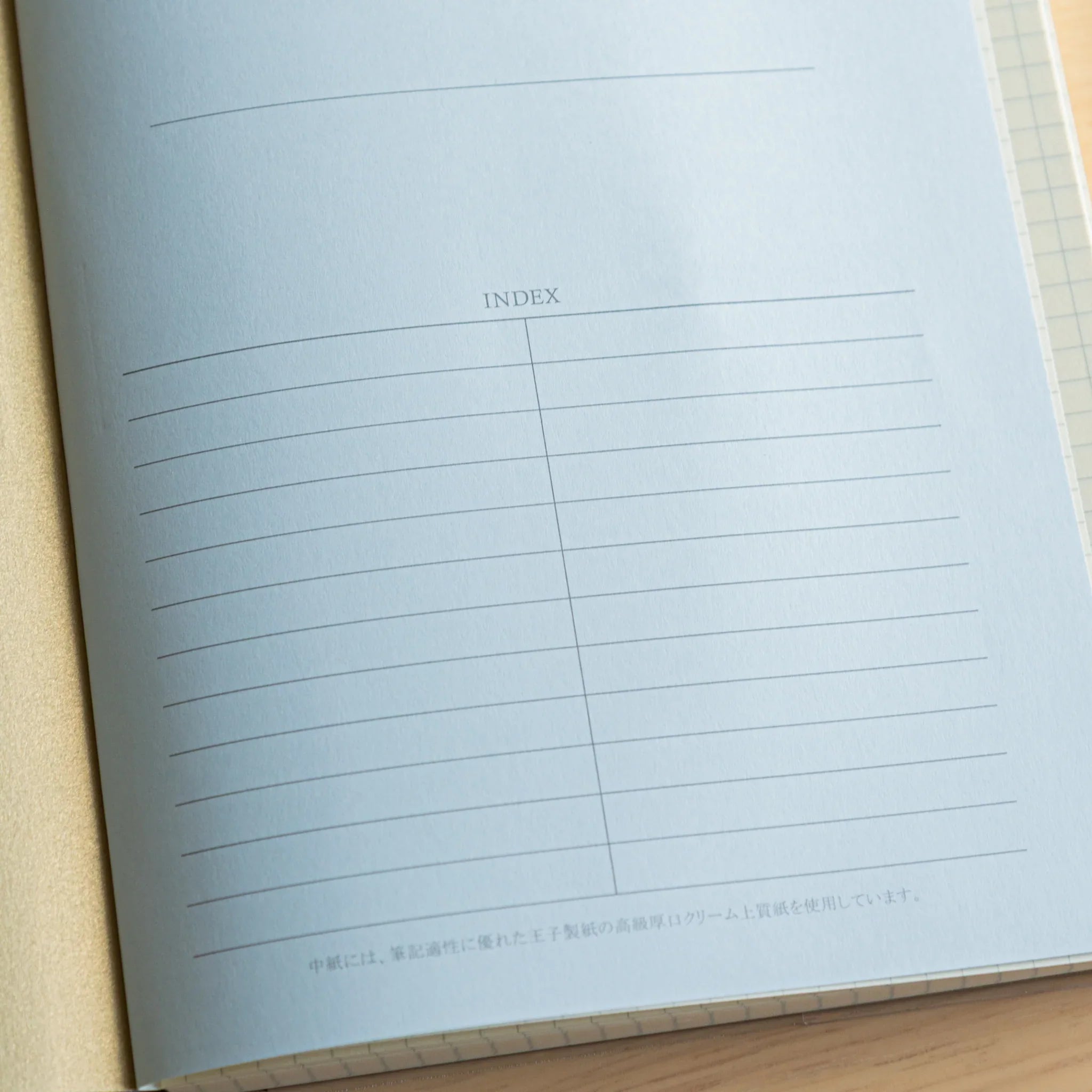 Premium CD A5 notebook cream cover detail with open interior displaying blue-tinted lined pages and index section layout