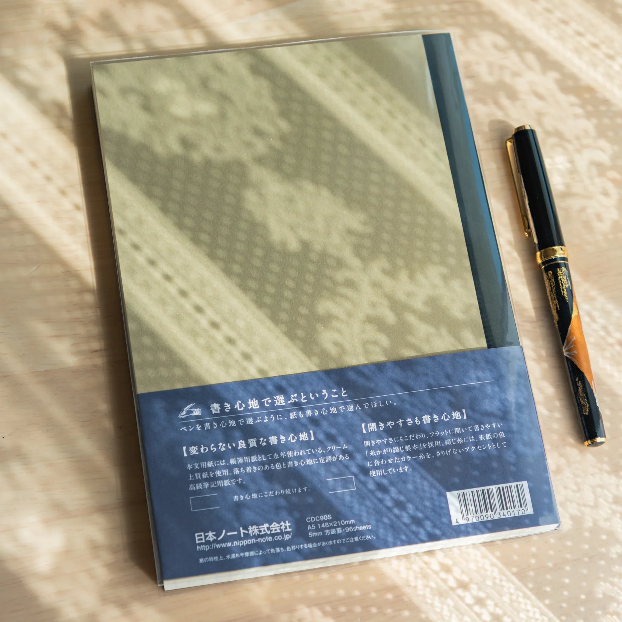 Apica Premium CD A5 soft cover notebook cream color open showing interior blue pages with fine line ruling, Japanese design