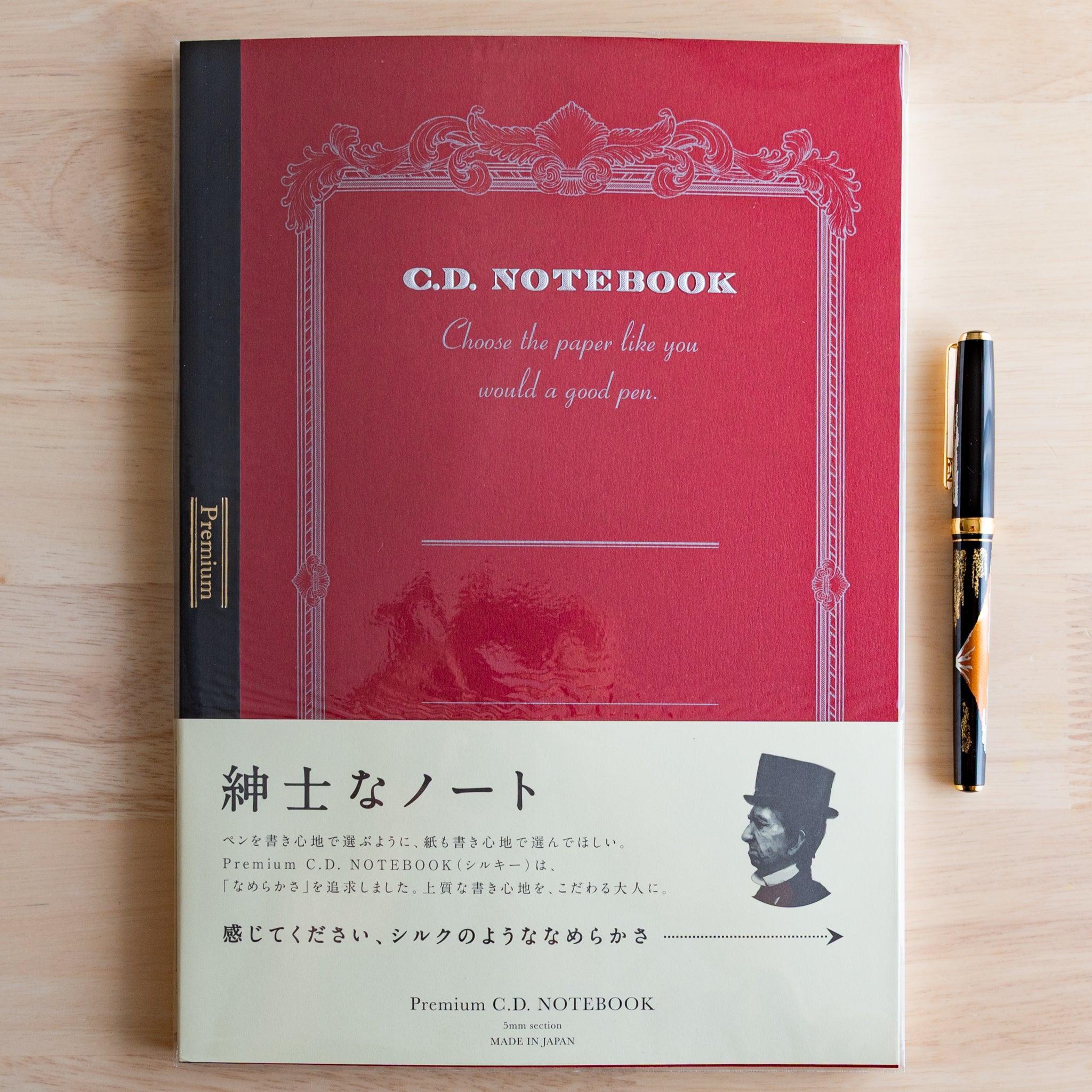Red A4 Premium CD Japanese notebook with cream band and fountain pen, highlighting its elegant paper for pen lovers.