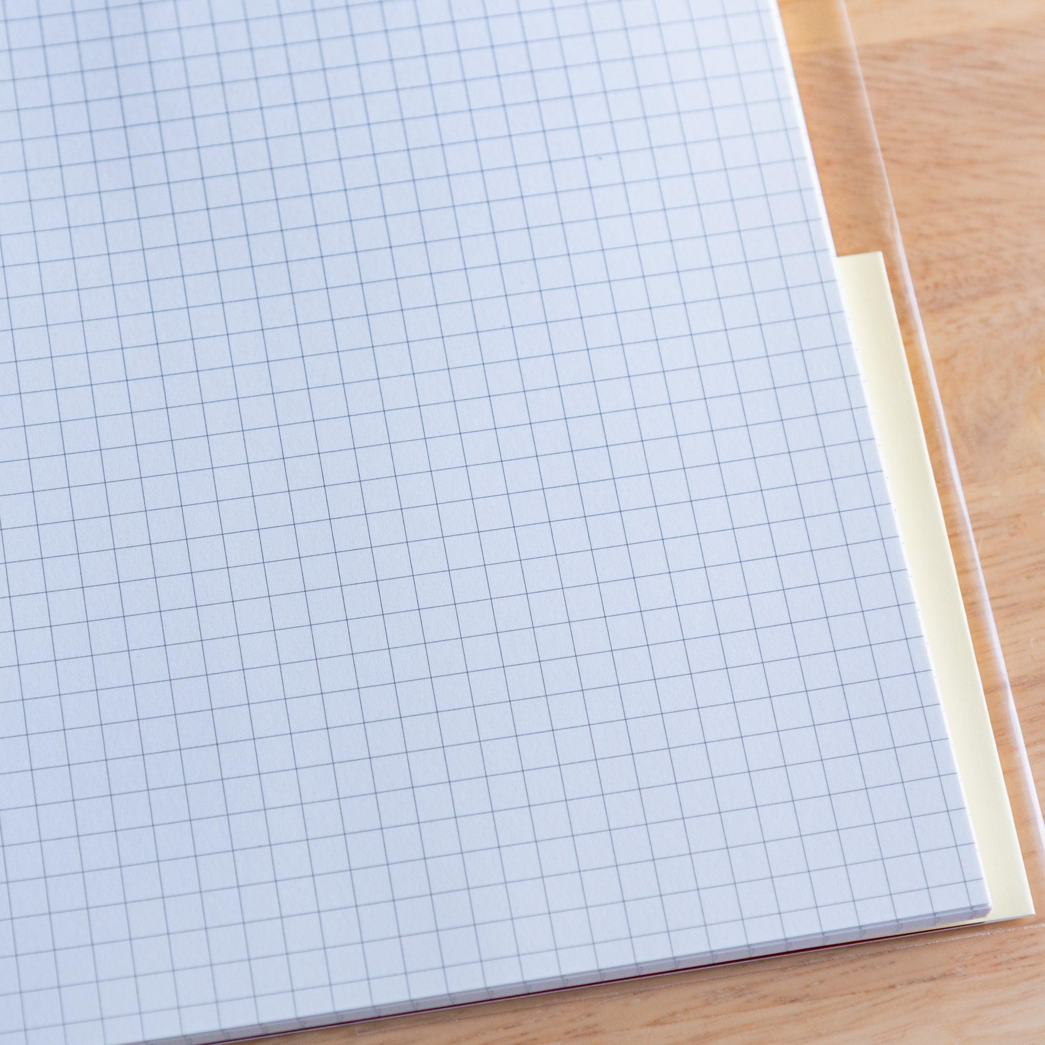 Close-up of grid white page in a Premium CD Japanese notebook, featuring smooth texture for fountain pen writing.