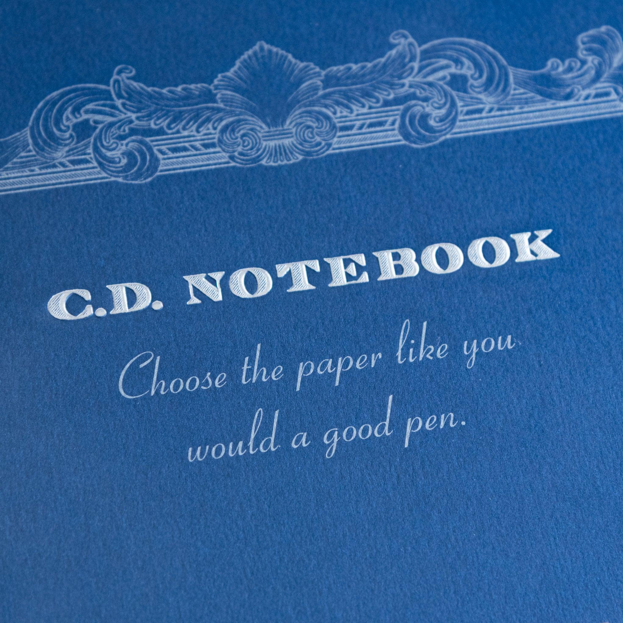 Close-up of blue Premium CD Japanese notebook cover with elegant border and quote about quality paper for a good pen.