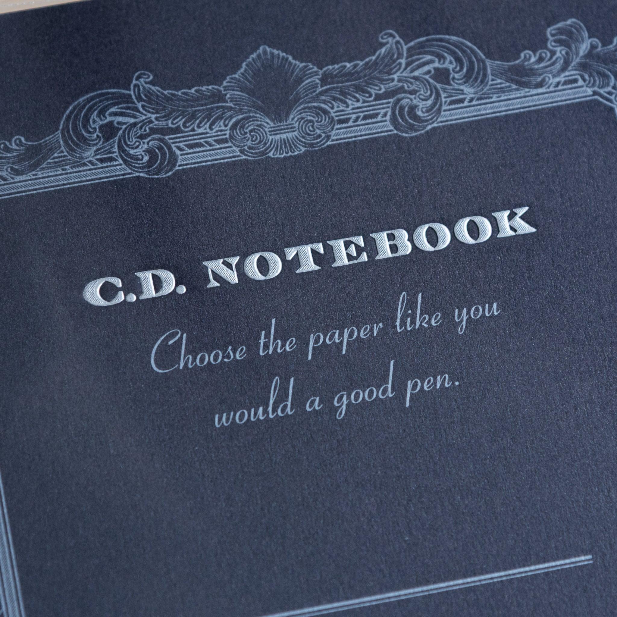 Close-up of black Premium CD Japanese notebook cover with elegant border and quote about quality paper for a good pen.