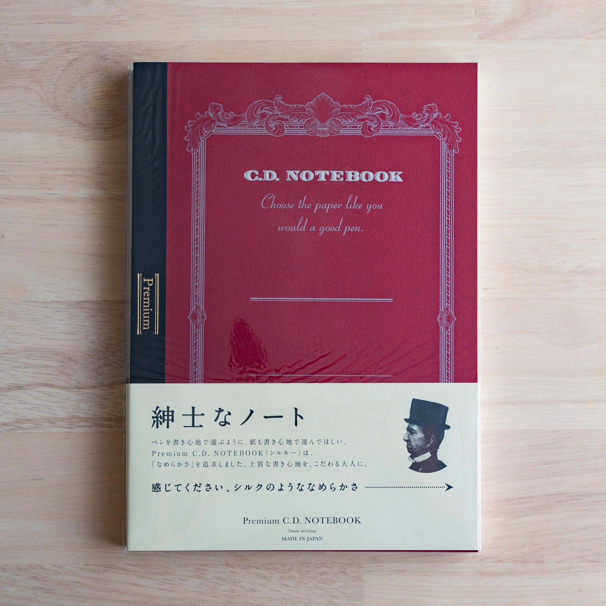 Red B5 Premium CD Japanese notebook with cream band and fountain pen, highlighting its elegant paper for pen lovers.