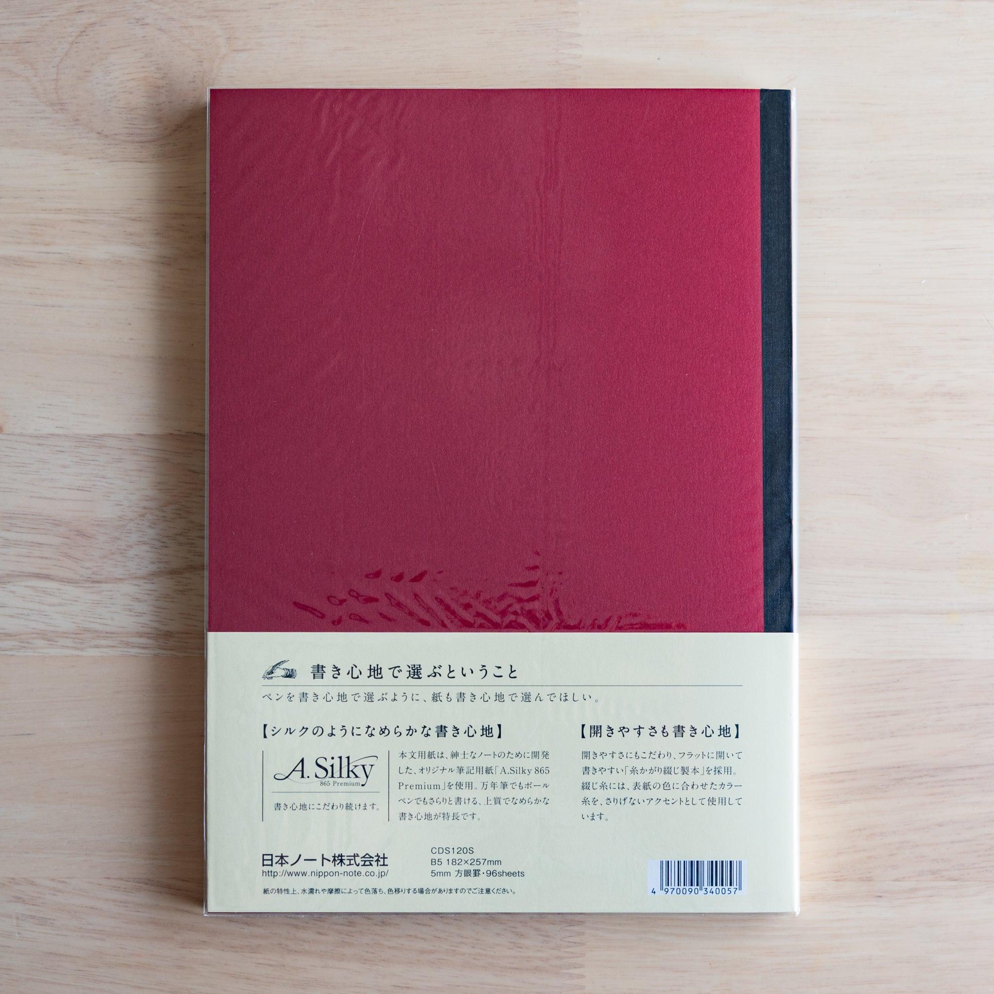Back of red Premium C.D. Japanese notebook with cream label explaining A.Silky 865 Premium paper.