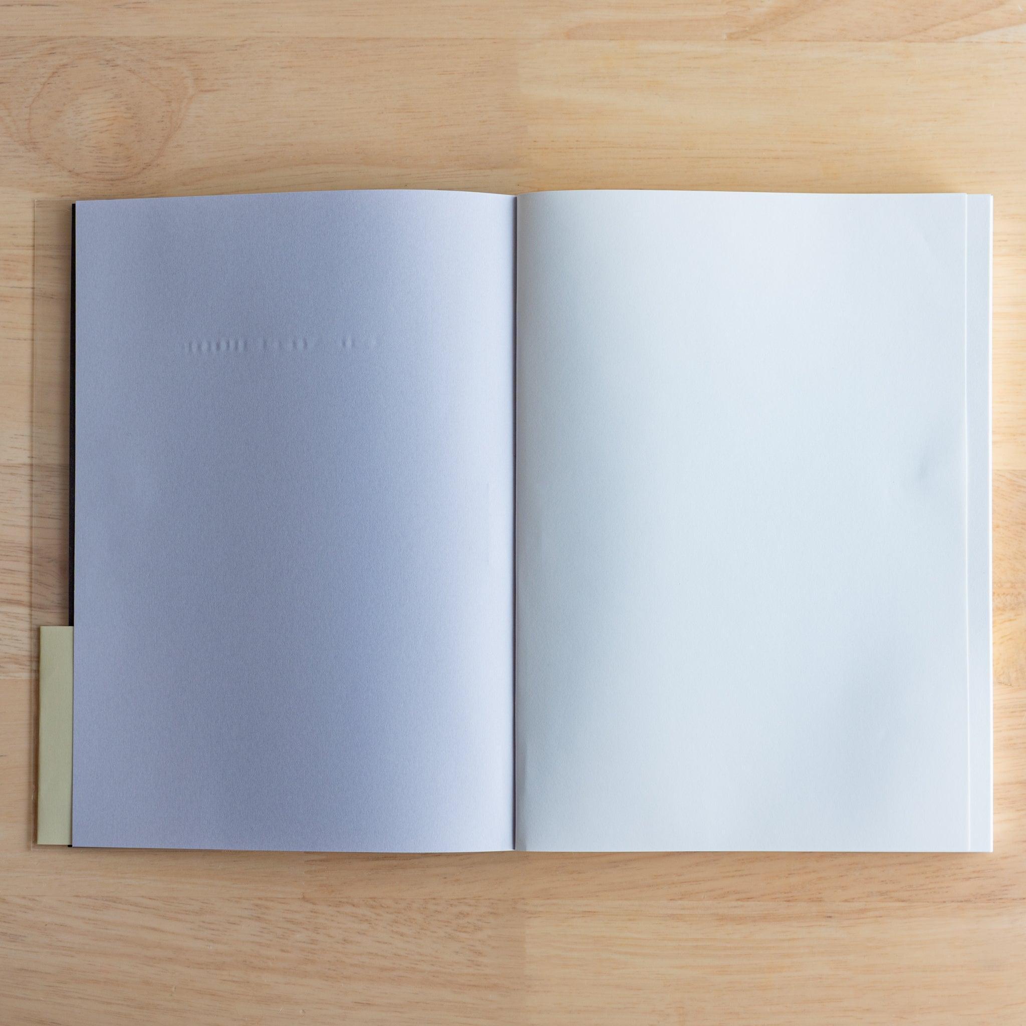 Open Premium CD Japanese notebook showing light blue plain pages designed for a silky writing experience.