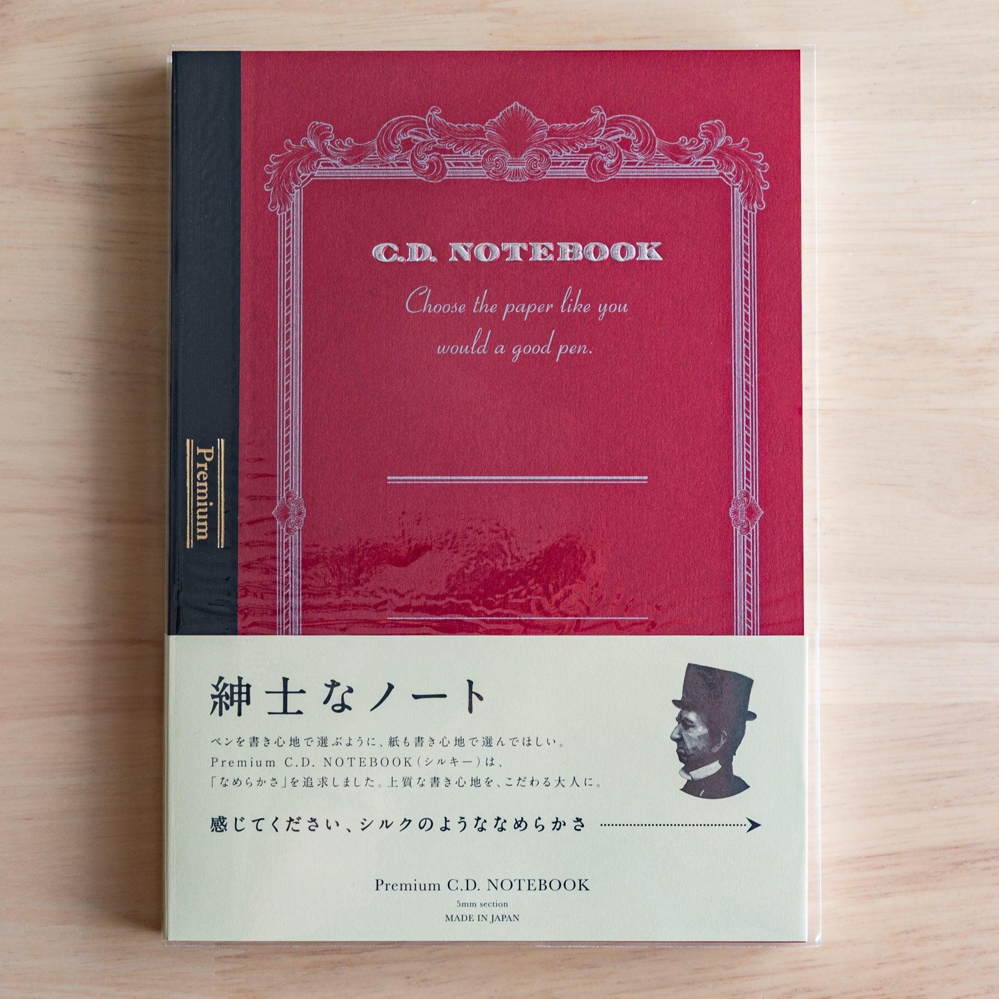 Red A5 Premium CD Japanese notebook with cream band and fountain pen, highlighting its elegant paper for pen lovers.