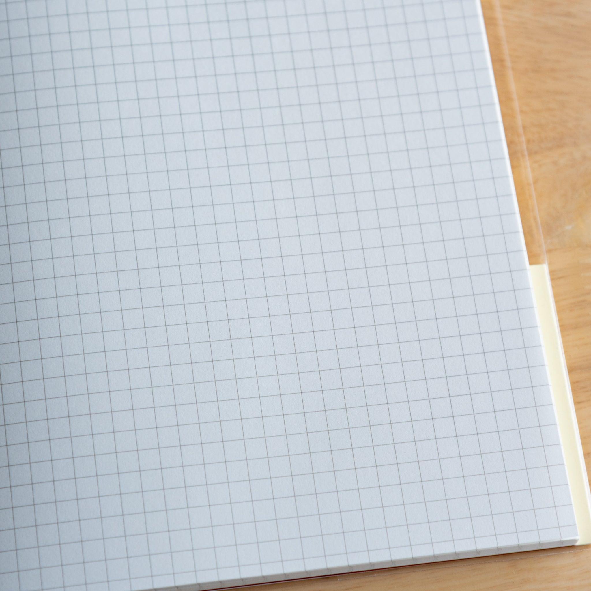 Close-up of grid white page in a Premium CD Japanese notebook, featuring smooth texture for fountain pen writing.