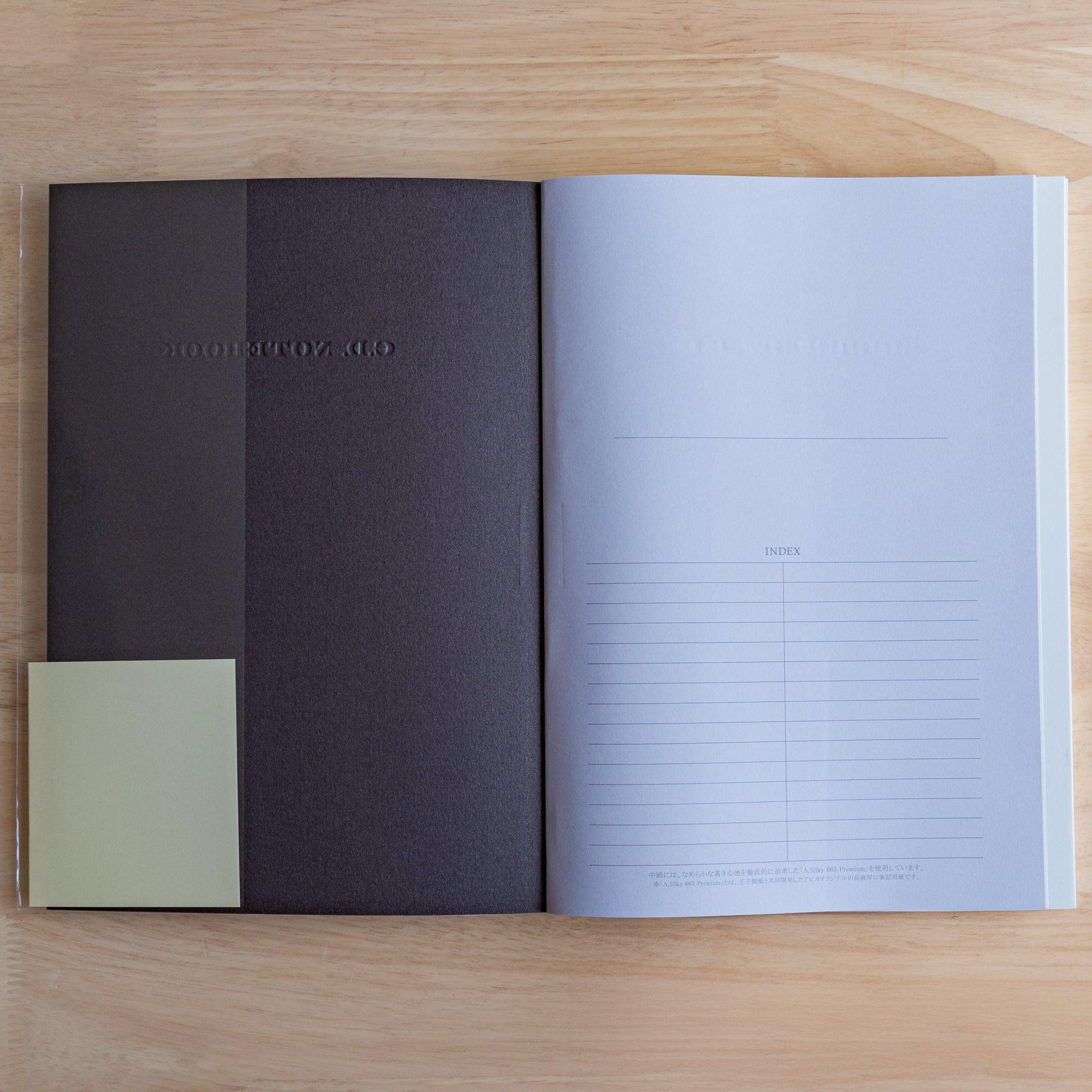 Inside view of a black Premium CD Japanese notebook showing textured inner cover and index page.