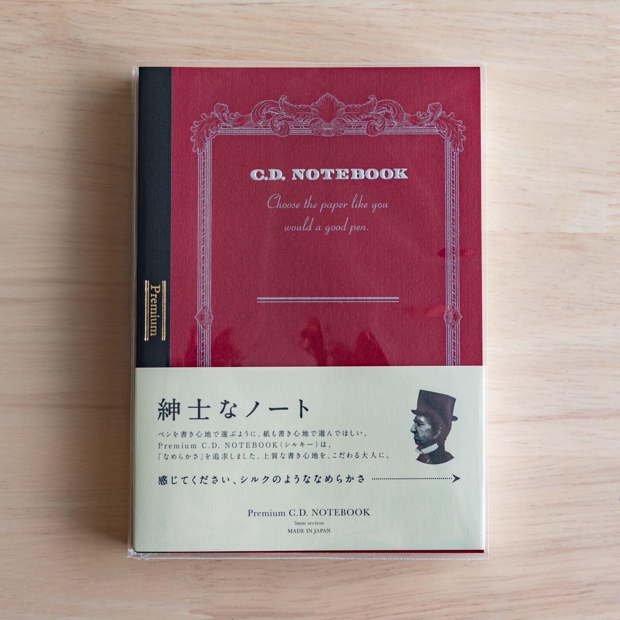 Red A6 Premium CD Japanese notebook with cream band and fountain pen, highlighting its elegant paper for pen lovers.