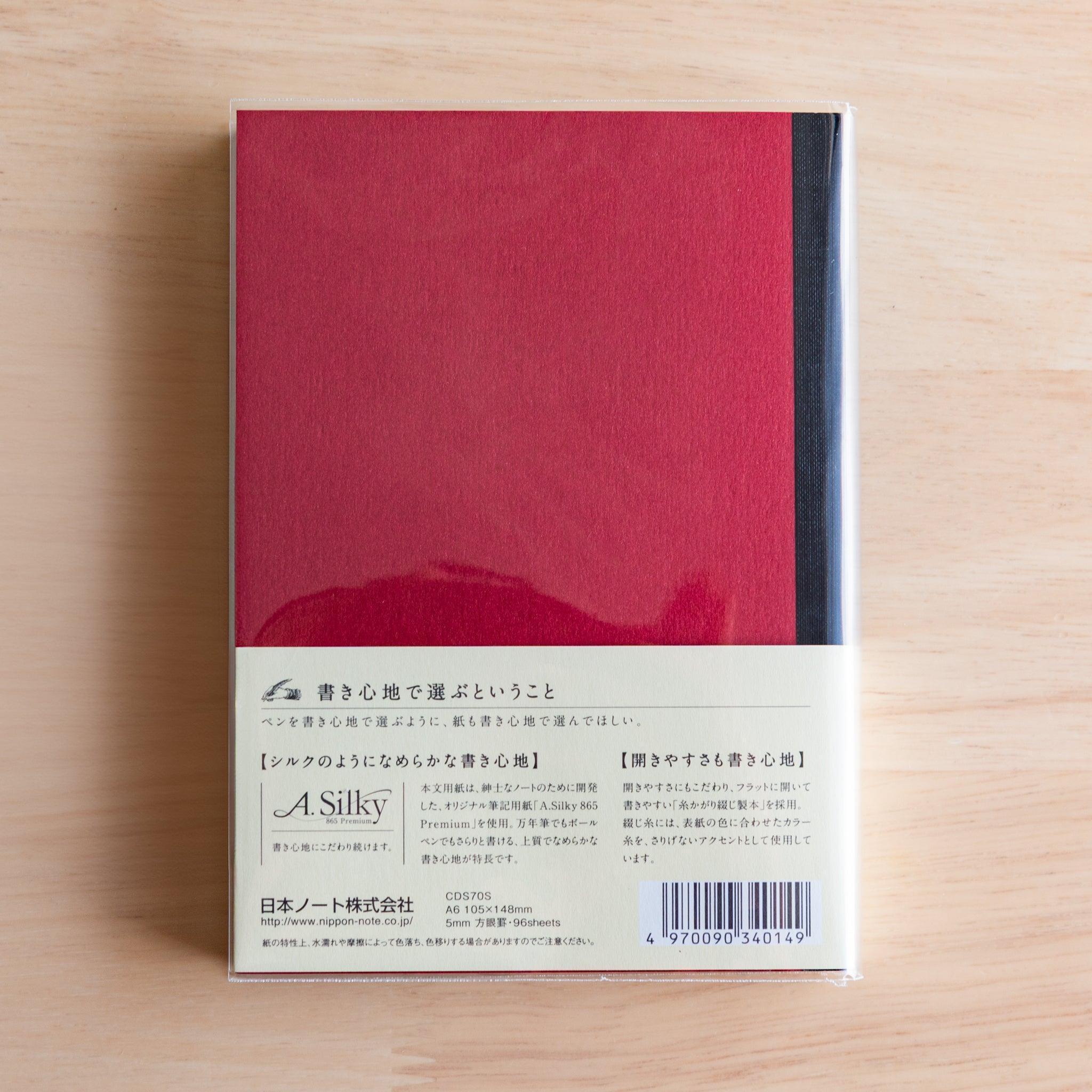Back of red Premium C.D. Japanese notebook with cream label explaining A.Silky 865 Premium paper.