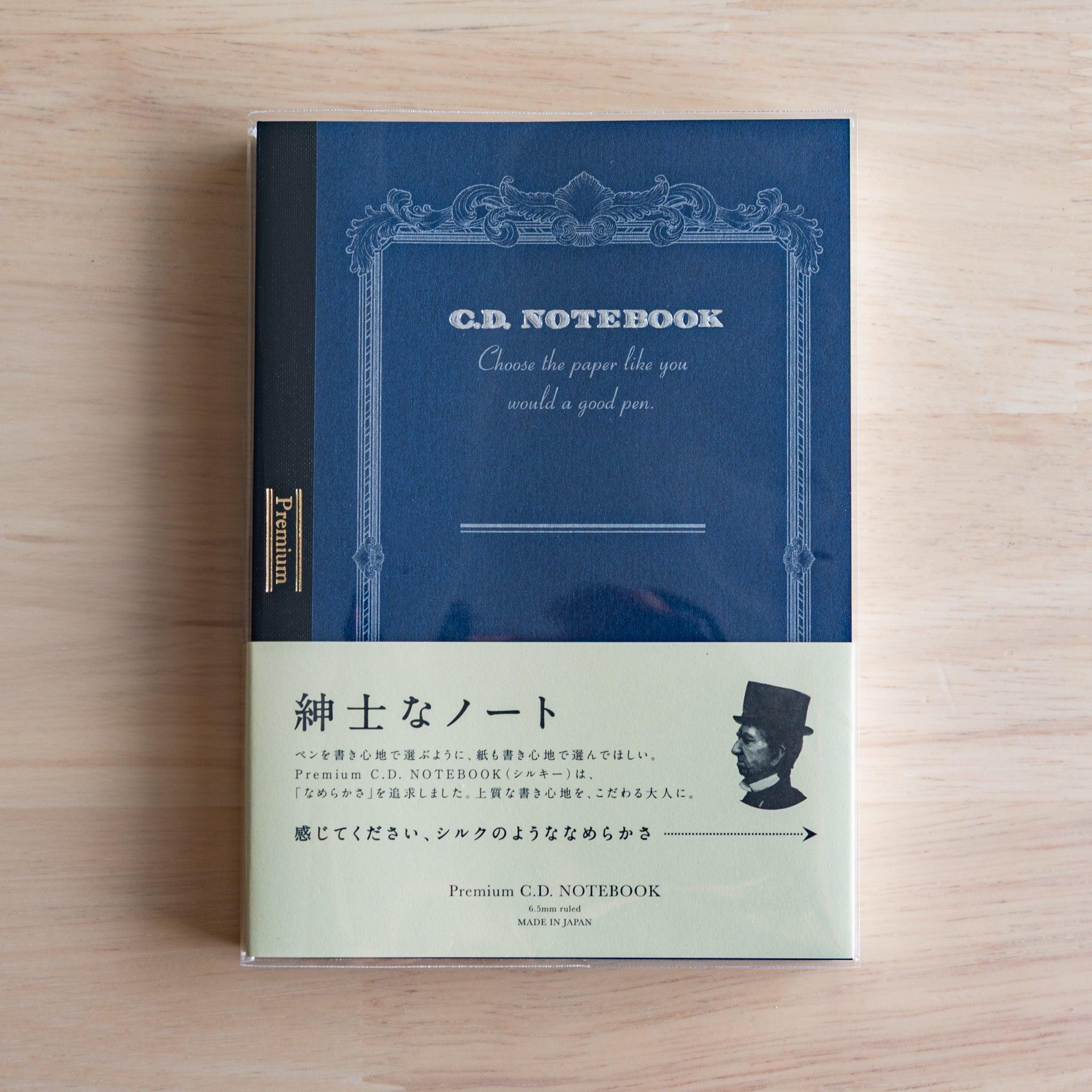 Blue A6 Premium CD Japanese notebook with cream band and fountain pen, highlighting its elegant paper for pen lovers.