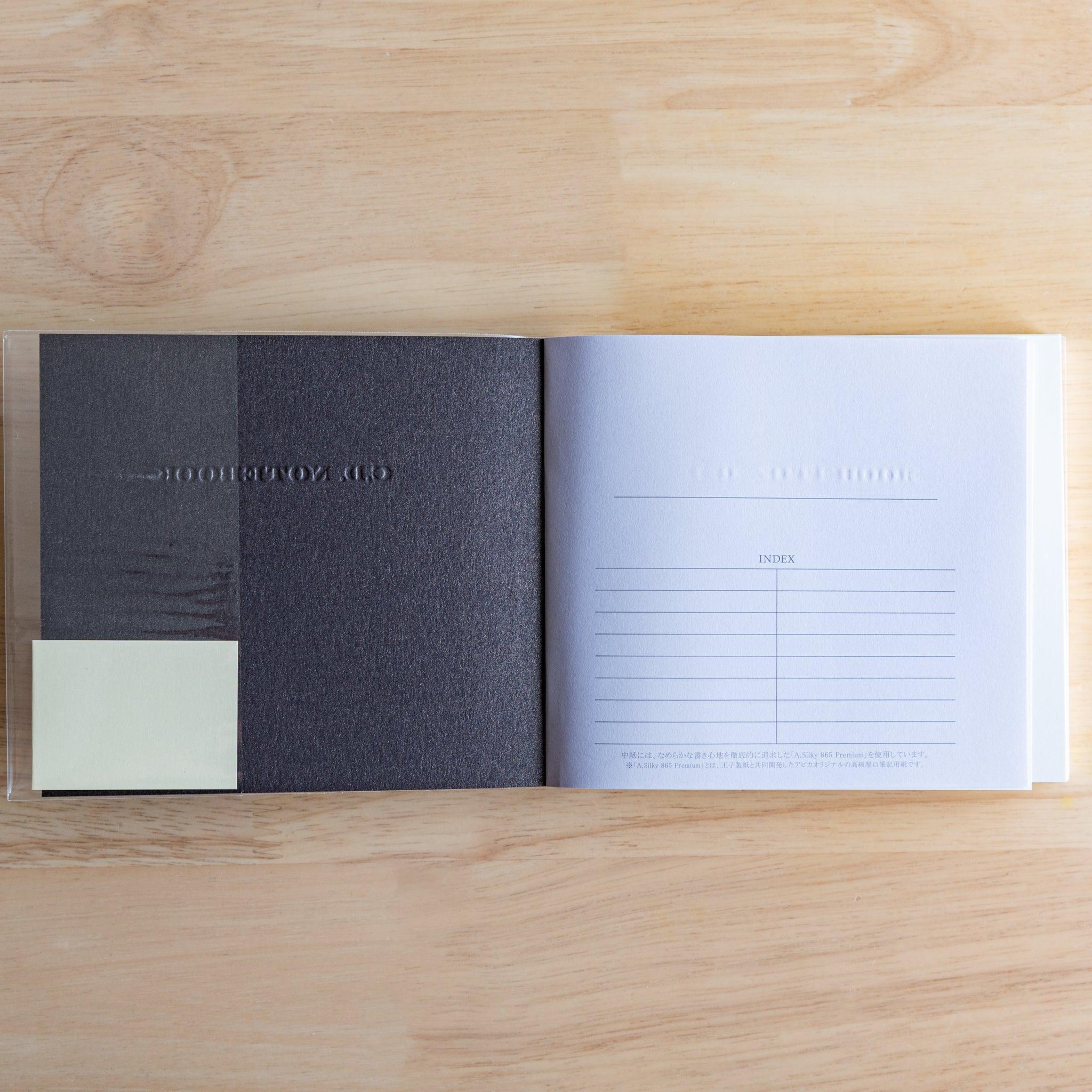 Inside view of a black Premium CD Japanese notebook showing textured inner cover and index page.