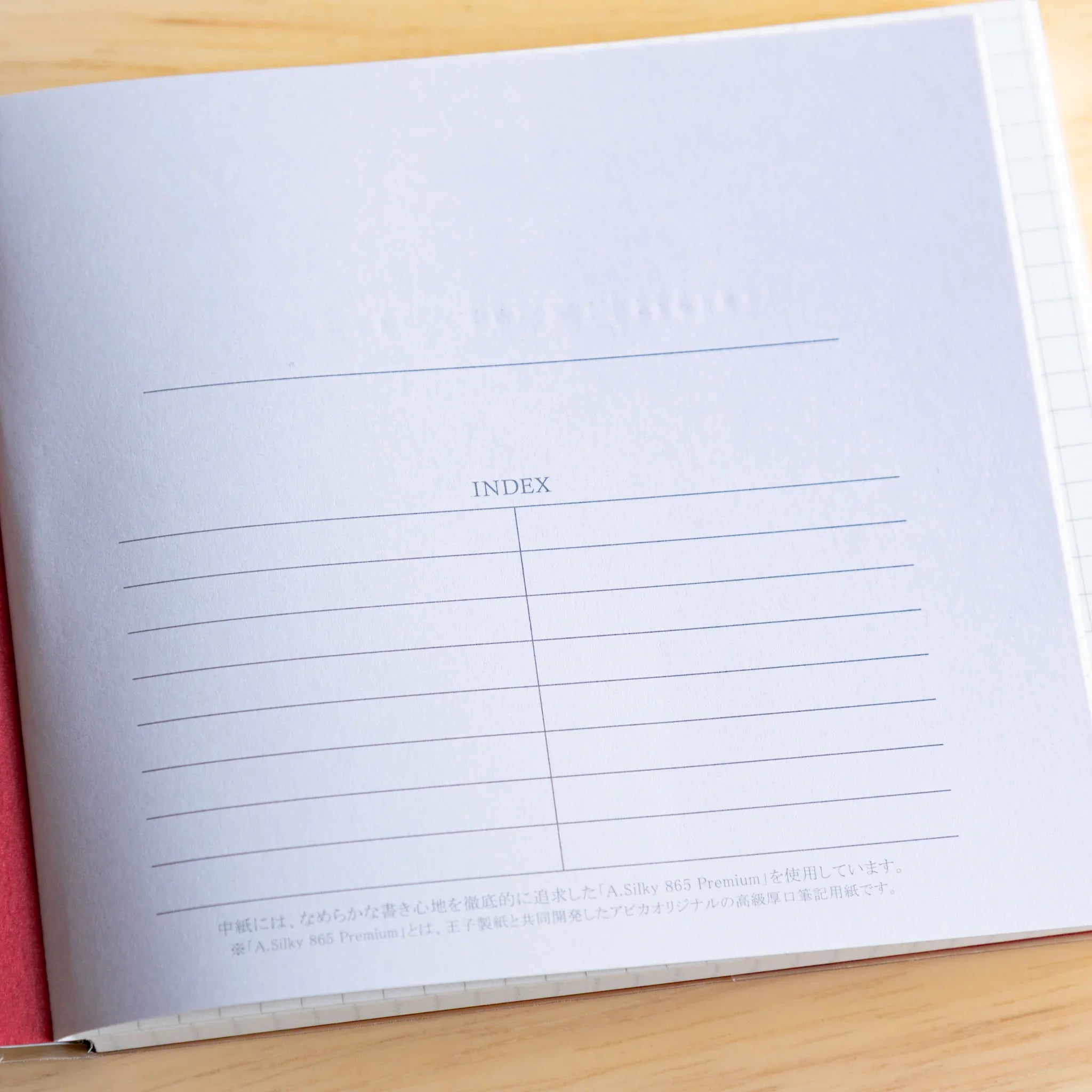 Apica Premium CD Silky notebook closed navy cover on wooden surface product photography detail Japanese made