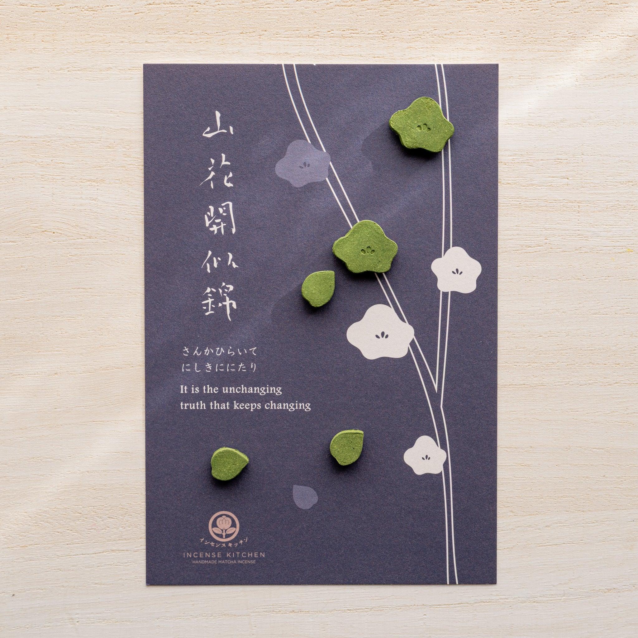 Plum variant pressed matcha incense card, dark navy with white plum blossom branch and small green plum-shaped pressed pieces