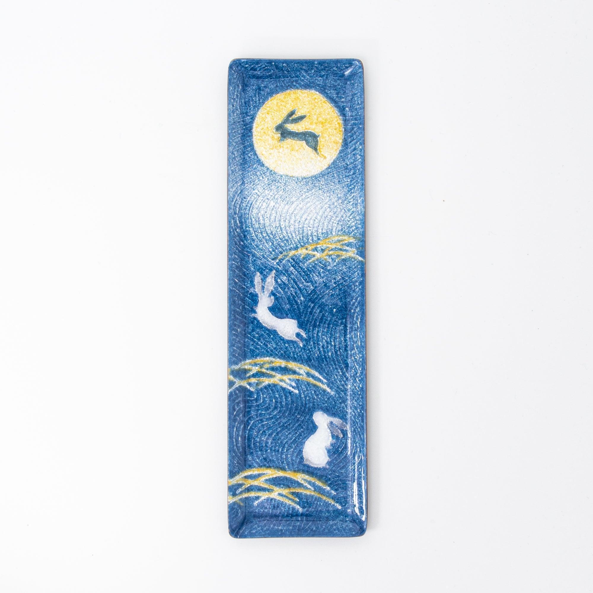 A vertical shot of a Japanese stationery tray with rabbit and moon design, emphasizing the detailed golden grass accents.