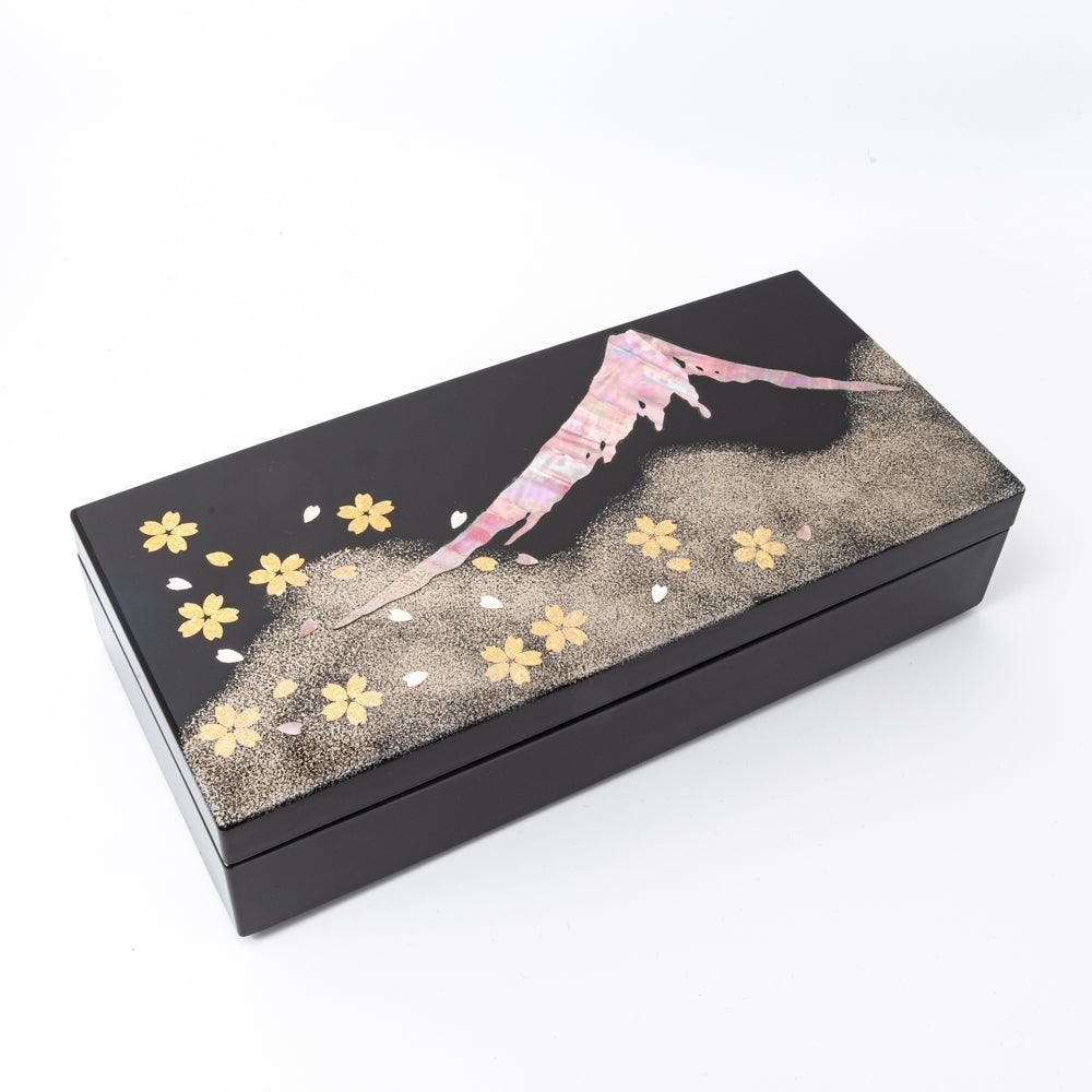Black lacquer Japanese pen box closed with raden sakura Fuji design on lid, three-quarter angled view on white background