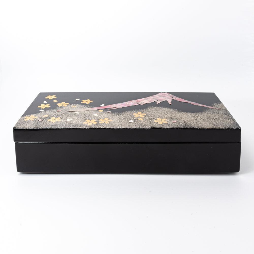 Front view of a black lacquer pen case adorned with Mt. Fuji and sakura motifs in shimmering gold and pink, reflecting Japanese artistry.