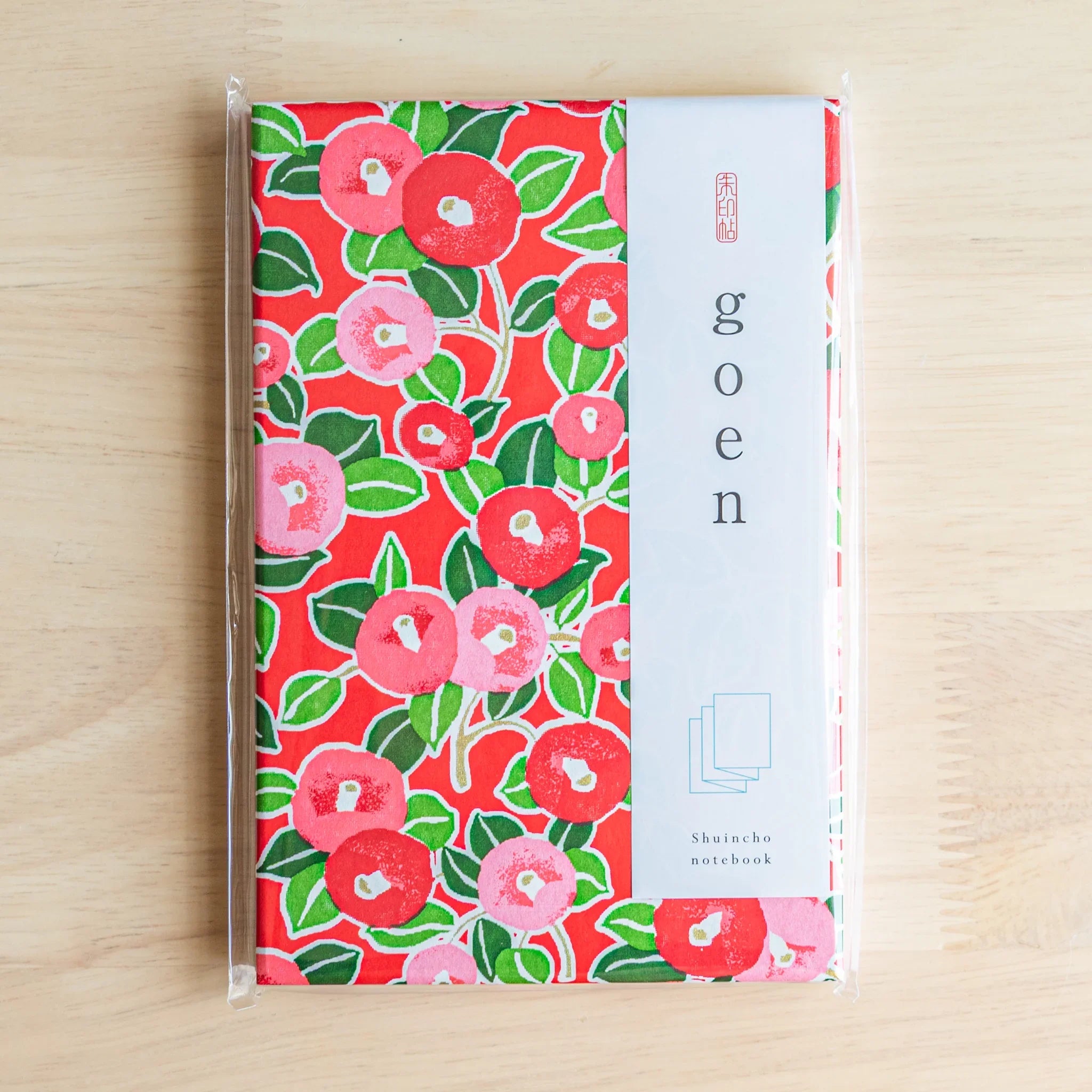 Red Camellia washi goshuincho in original packaging with white goen belly band showing Shuincho notebook label on light wood