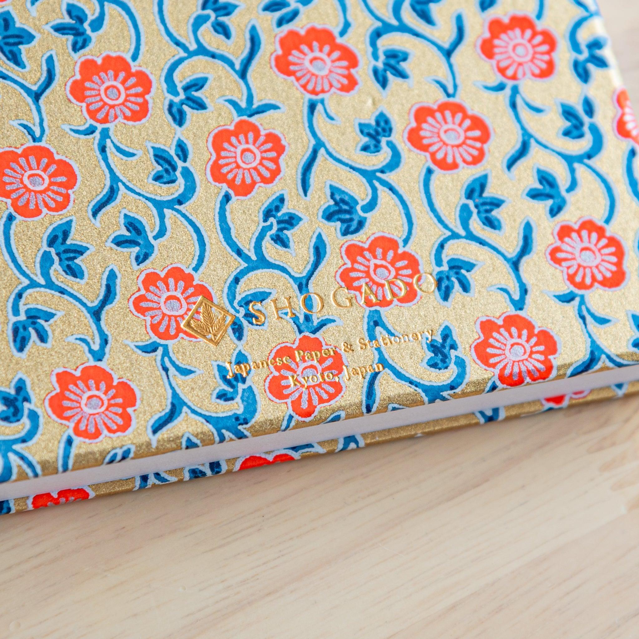 Close-up of gold washi Goshuinsho stamp book with red floral pattern by SHOGADO, Kyoto, Japan. Beautiful Japanese stationery.