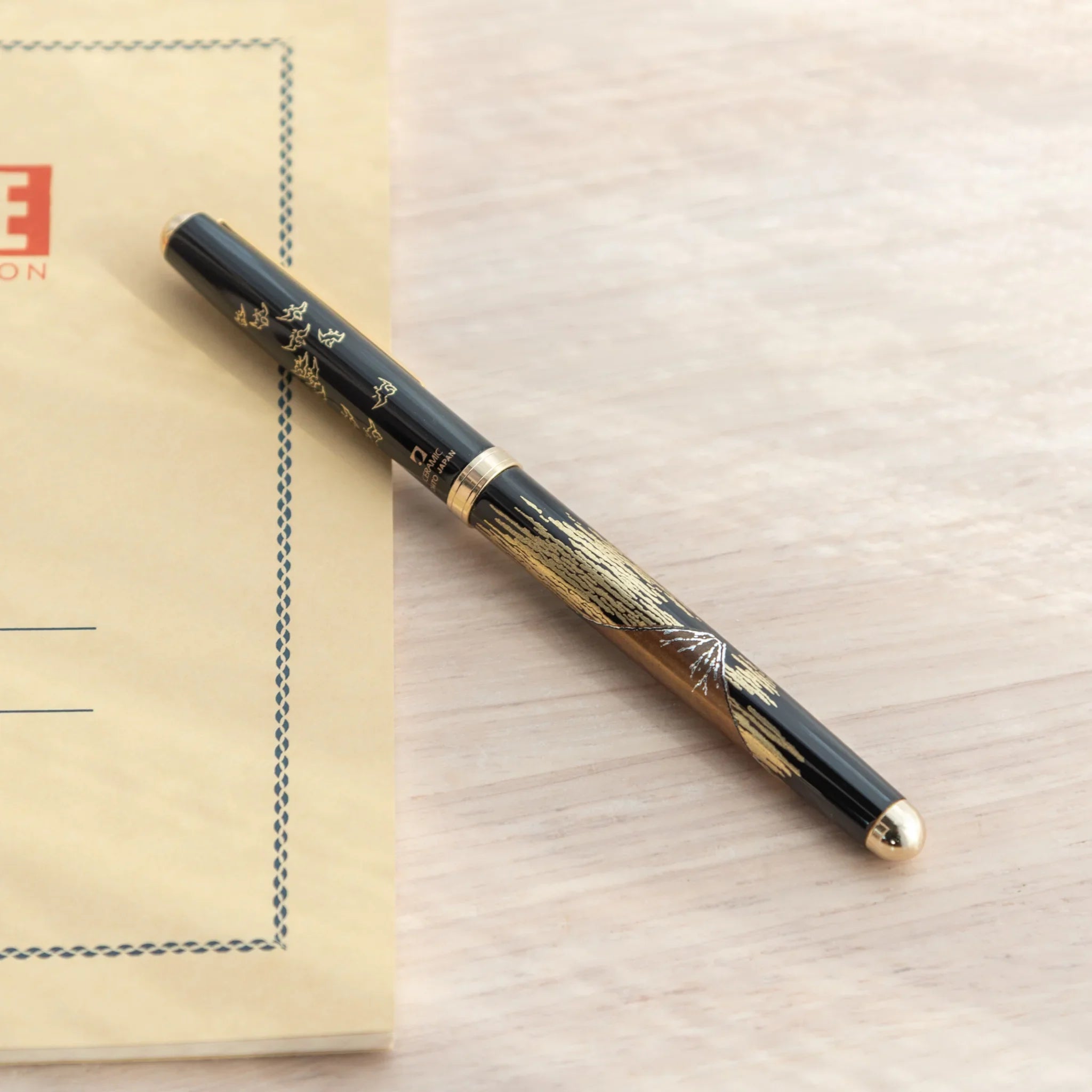 Japanese Ballpoint Pen with detailed Lacquer red Mt.Fuji design placed on the desk.
