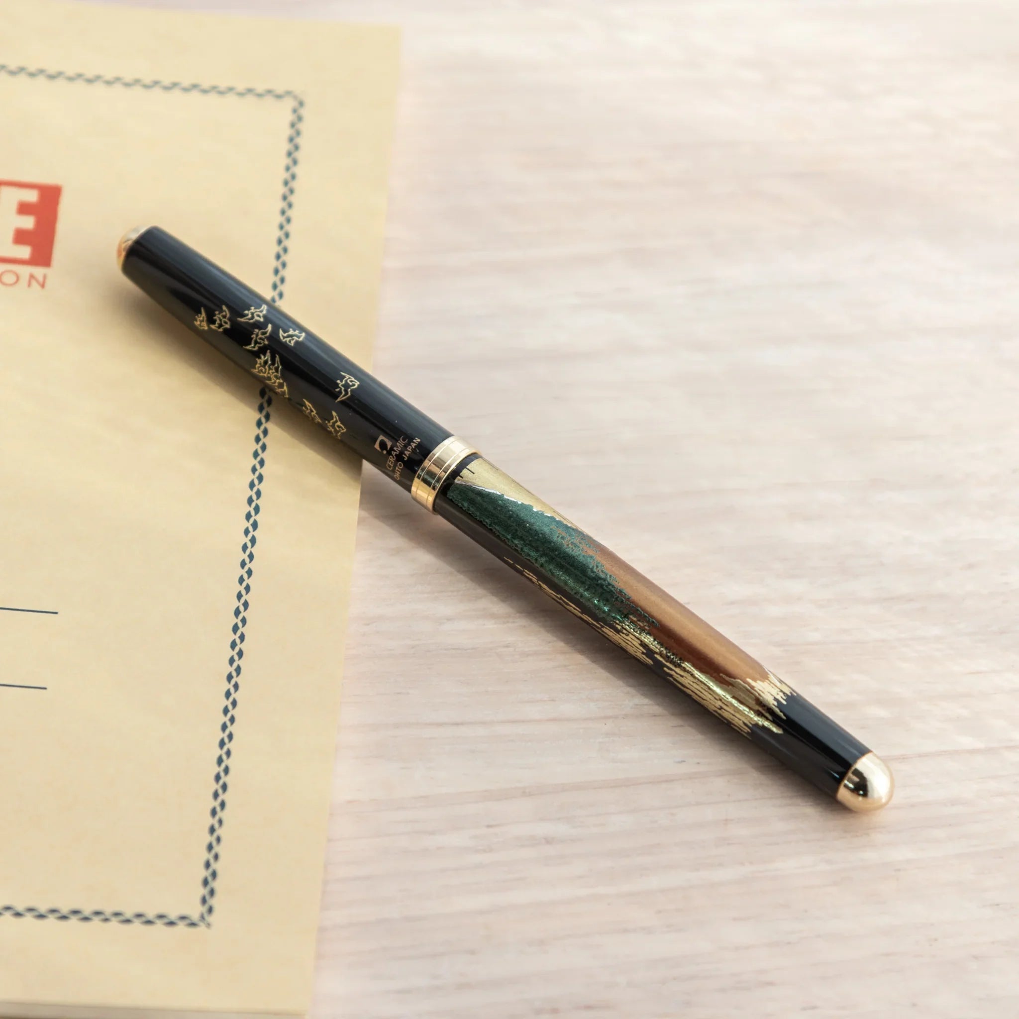 Japanese Ballpoint Pen with detailed Lacquer red Mt.Fuji design placed on the desk.