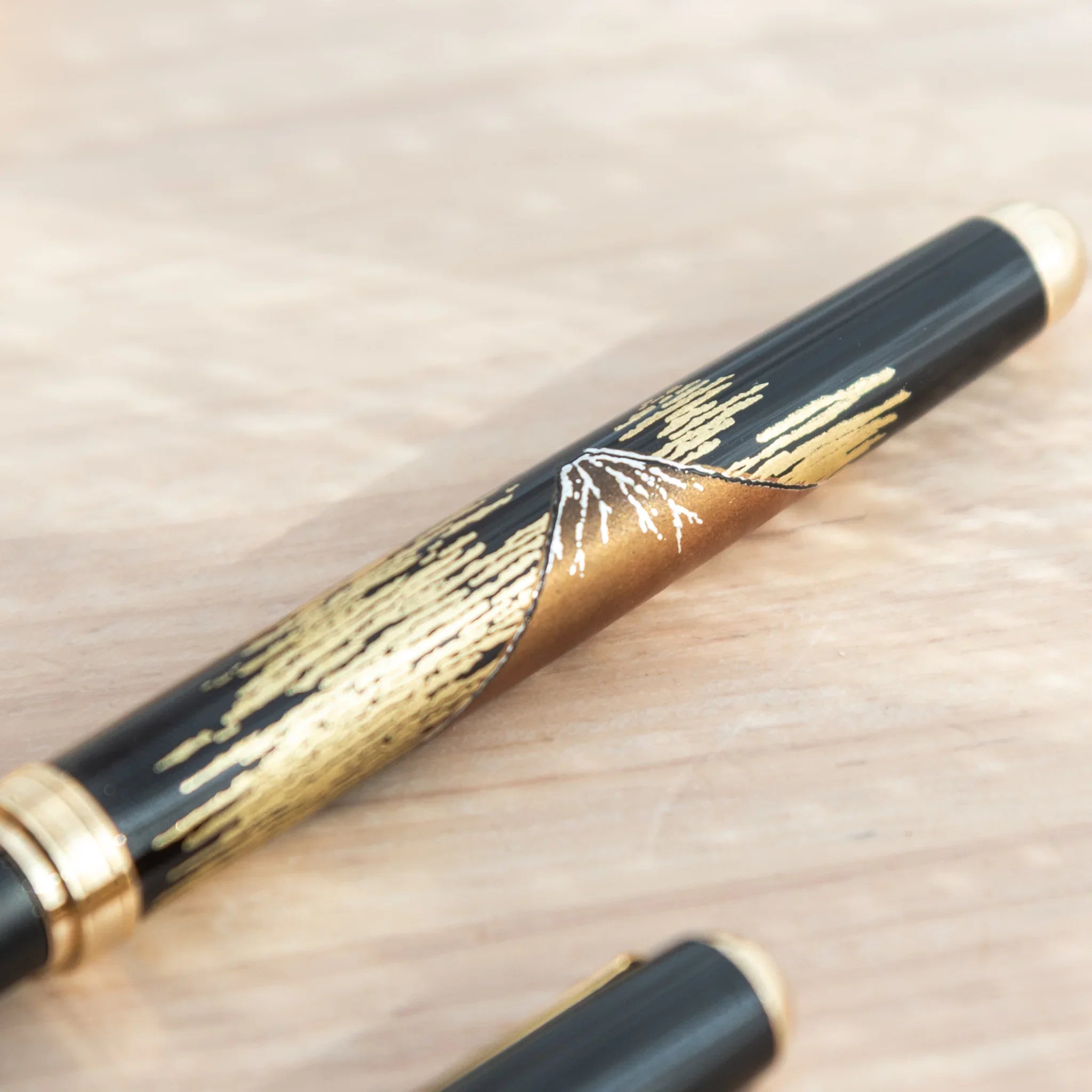 Yamanaka lacquer ballpoint pen displays hand-painted red fuji in warm lacquer colors and gold for writing