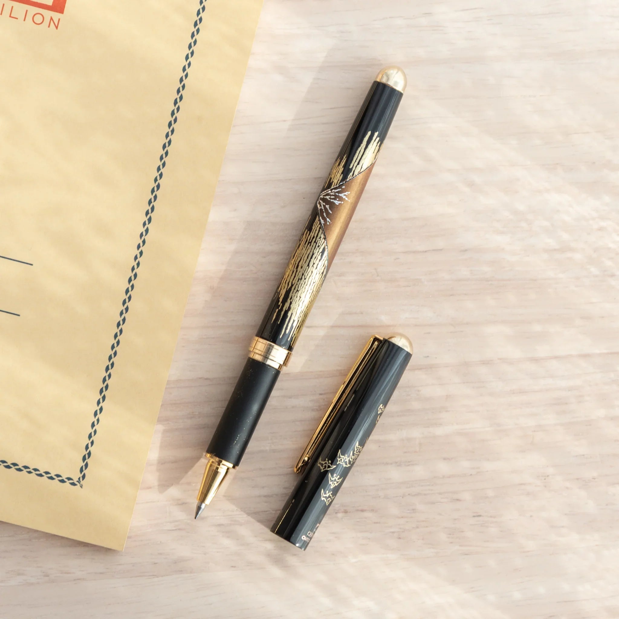 Yamanaka made ballpoint pen displays red fuji artwork with metallic gold leaf accents for writing, Japanese lacquer art