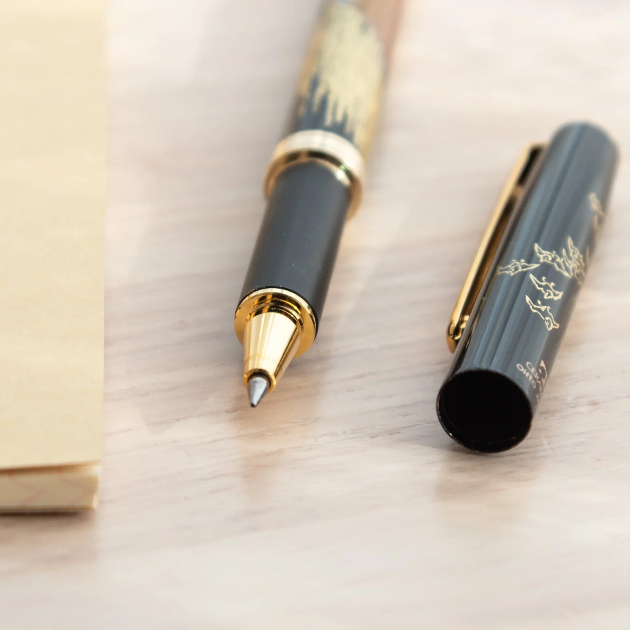 Uncapped Japanese Ballpoint Pen showcasing Red Fuji Lacquer design and a finely crafted gold tip.