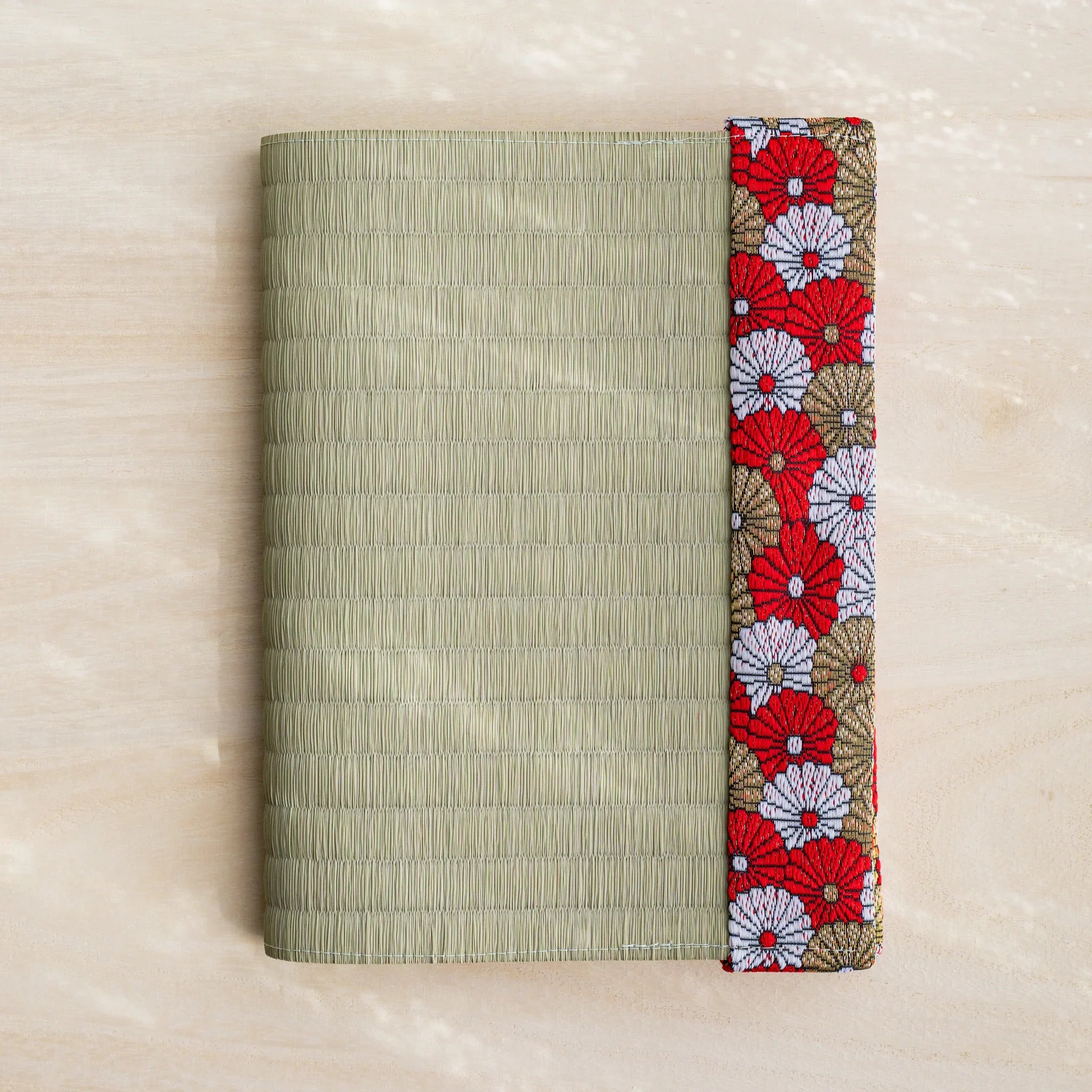 Red Imperial Chrysanthemum tatami book cover closed, green rush straw with red white and gold Japanese chrysanthemum band